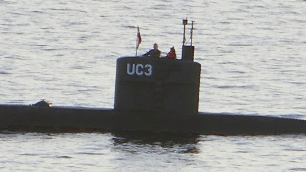 Allegedly Swedish journalist Kim Wall stands next to a man in the tower of the private submarine "UC3 Nautilus" on August 10, 2017 in Copenhagen Harbor. Danish police said Sunday they searched a huge DIY submarine that sank last week in the hunt for the missing journalist who had been aboard before it sank, but no body was found. - / AFP PHOTO / Peter THOMPSON