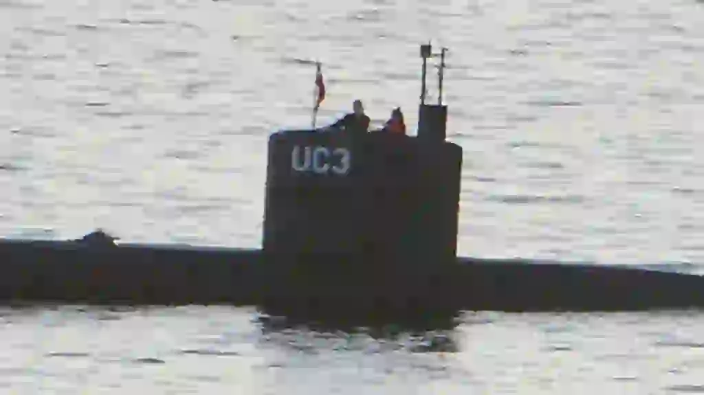 Allegedly Swedish journalist Kim Wall stands next to a man in the tower of the private submarine "UC3 Nautilus" on August 10, 2017 in Copenhagen Harbor. Danish police said Sunday they searched a huge DIY submarine that sank last week in the hunt for the missing journalist who had been aboard before it sank, but no body was found. - / AFP PHOTO / Peter THOMPSON
