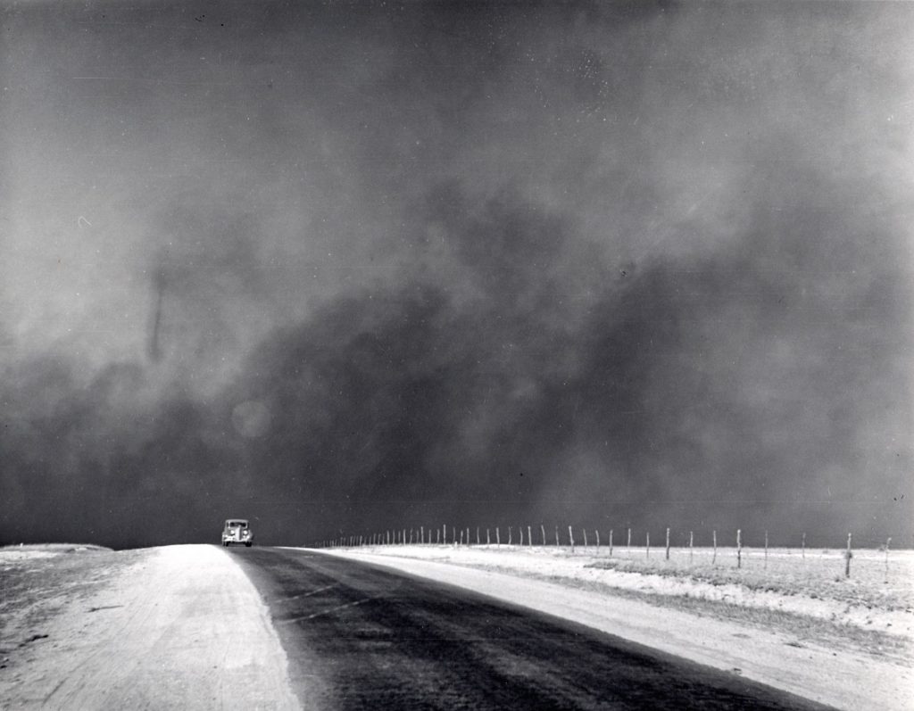Heavy black clouds of dust rising over the Texas Panhandle. Texas, 1936 March Photo: Dorothea Lange