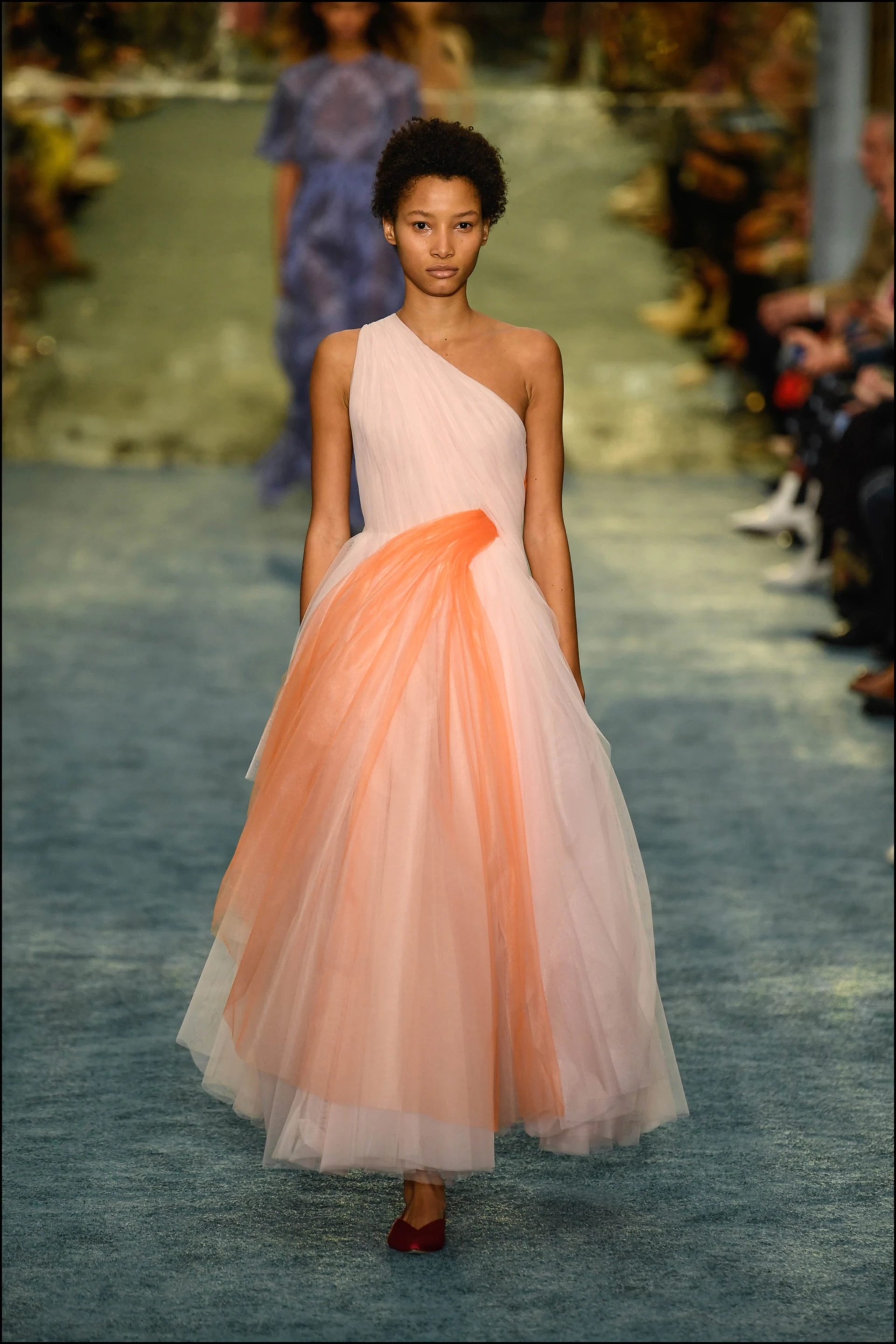 Vestido de un hombro ceñido a la cintura, de donde salía una discreta cascada de tejido anaranjado. 