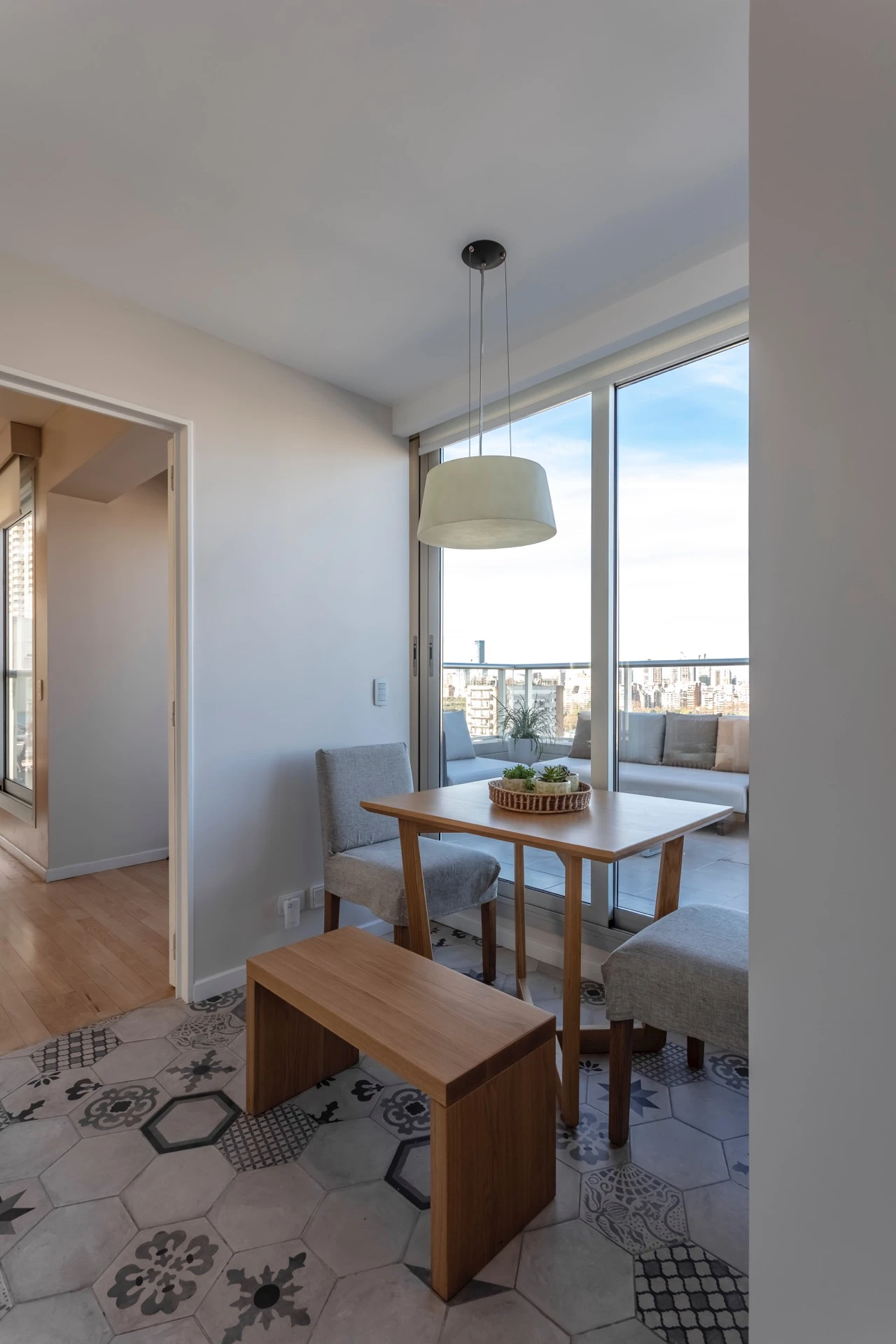 El pequeño comedor diario se rinde ante el ventanal que recorta una porción del cielo.