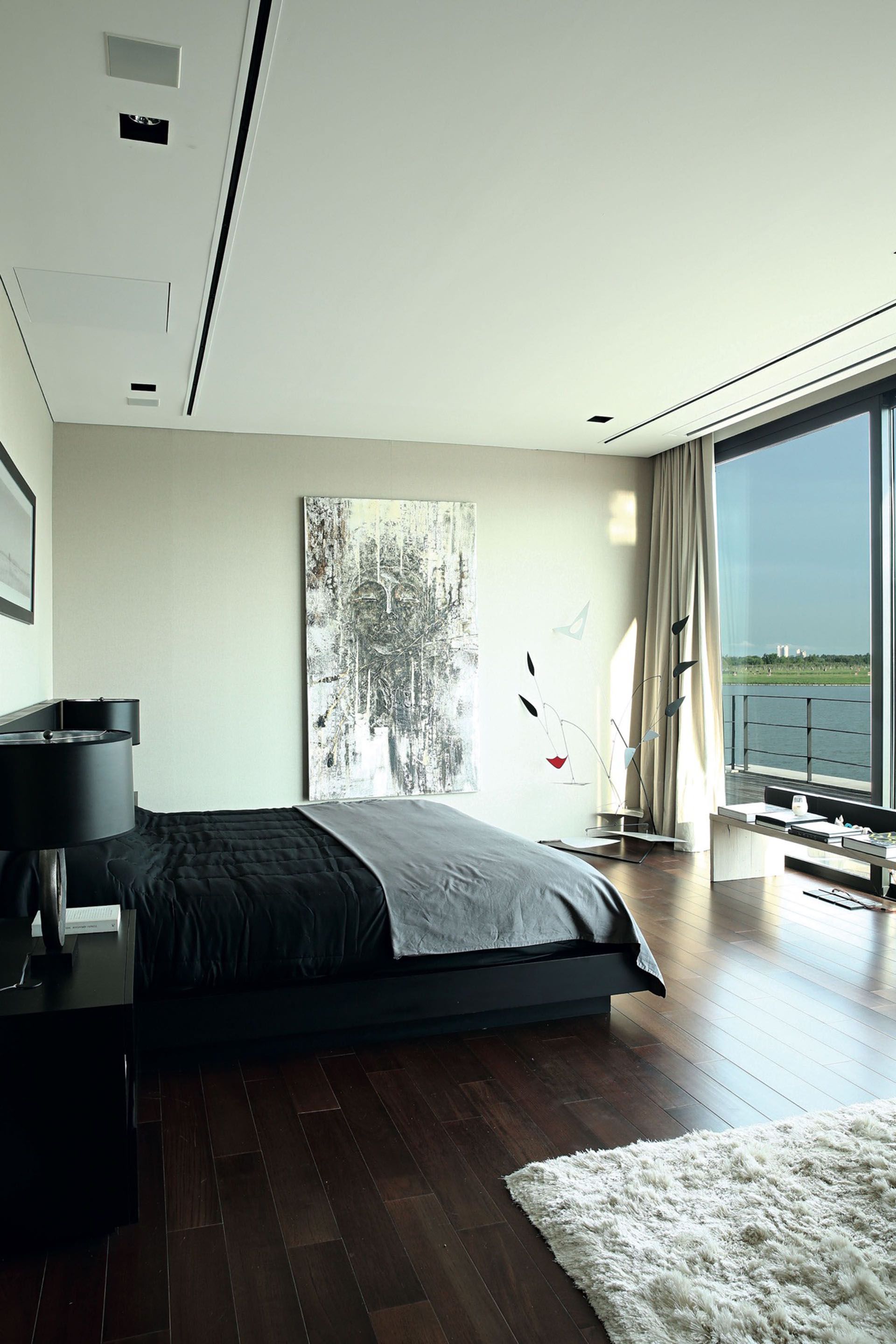 Una paleta muy estricta (gris + blanco + negro) viste el  moderno cuarto principal. El ventanal que mira a la laguna es protagonista.