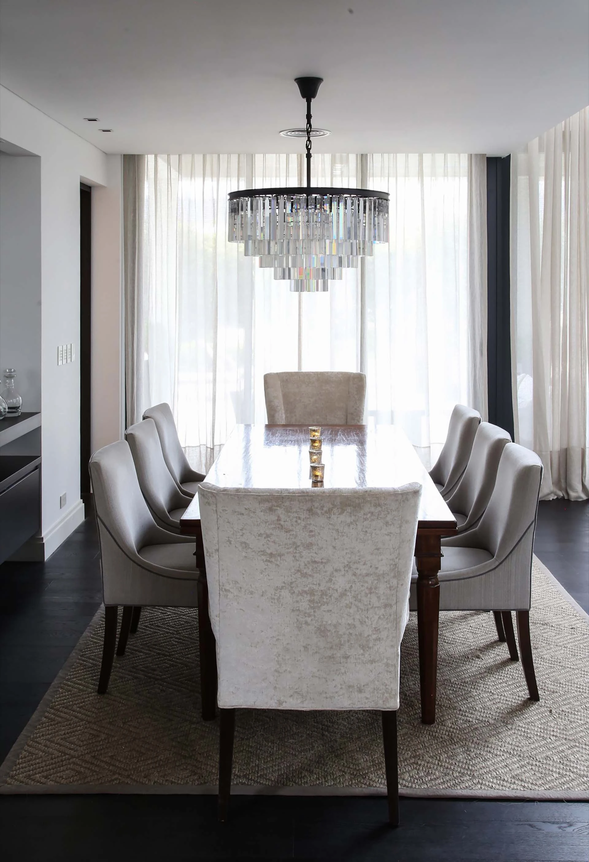 Toda la elegancia de la decoración encuentro su punto más alto en el comedor, con una imponente -pero moderno- araña de cristal.