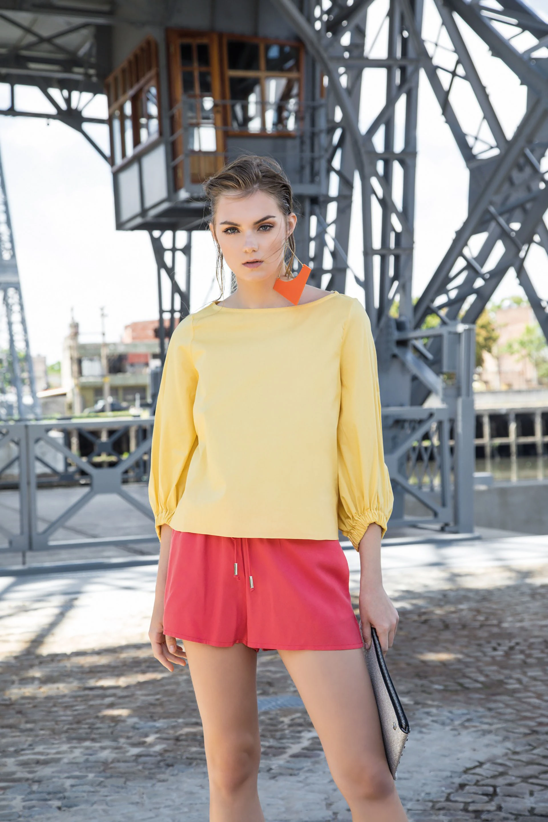 Blusa con manga capullo ($ 1.400, Clara Ibarguren), short deportivo ($ 1. 900, Vitamina), sobre plateado ($ 1.790, Prüne) y aros de acrílico ($ 1.600, Luna Garzón). Foto Fernando Venegas/ Para Ti