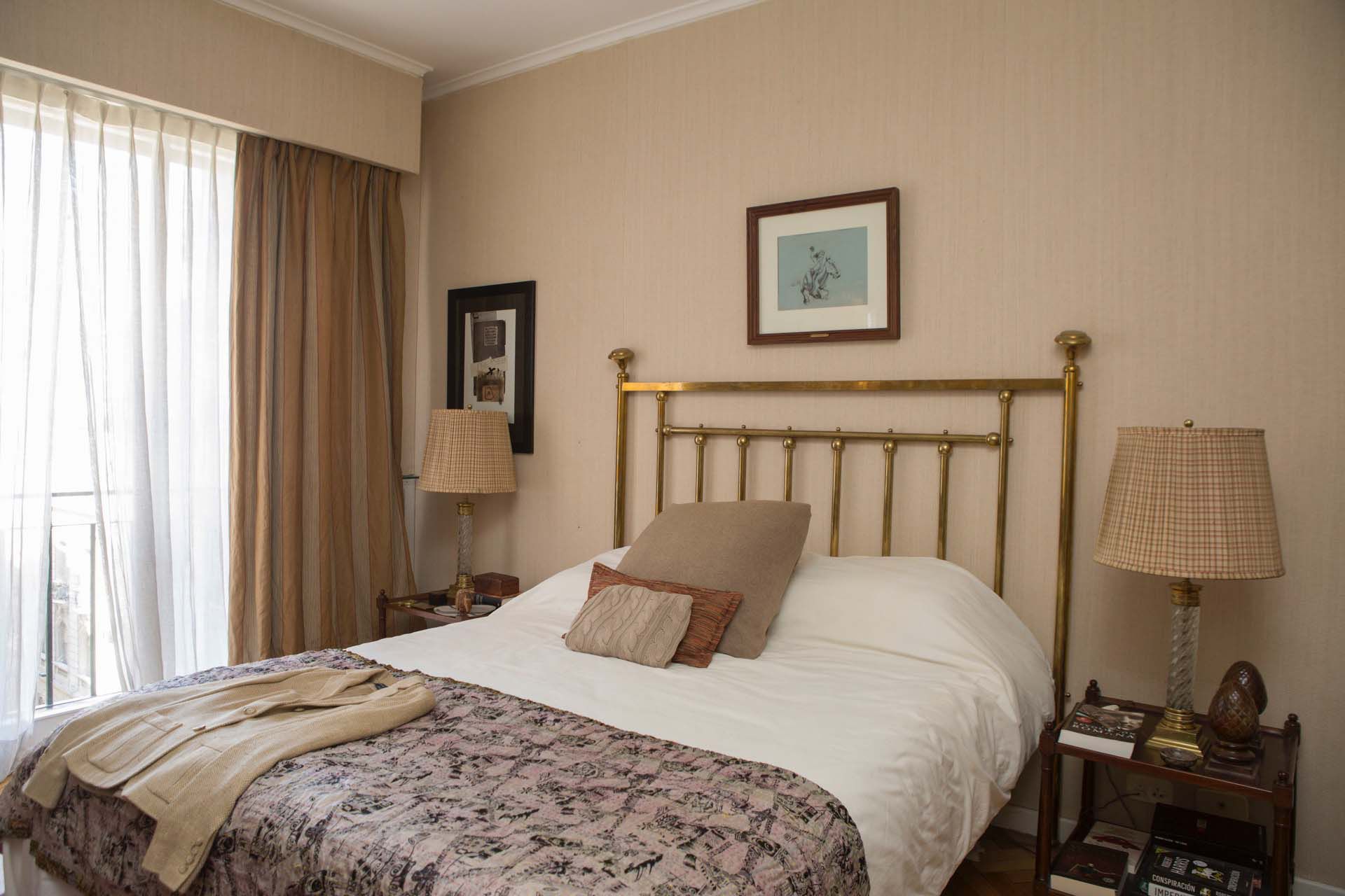 De corte más clásico, el dormitorio principal prefire la elegancia del bronce y la madera de caoba.