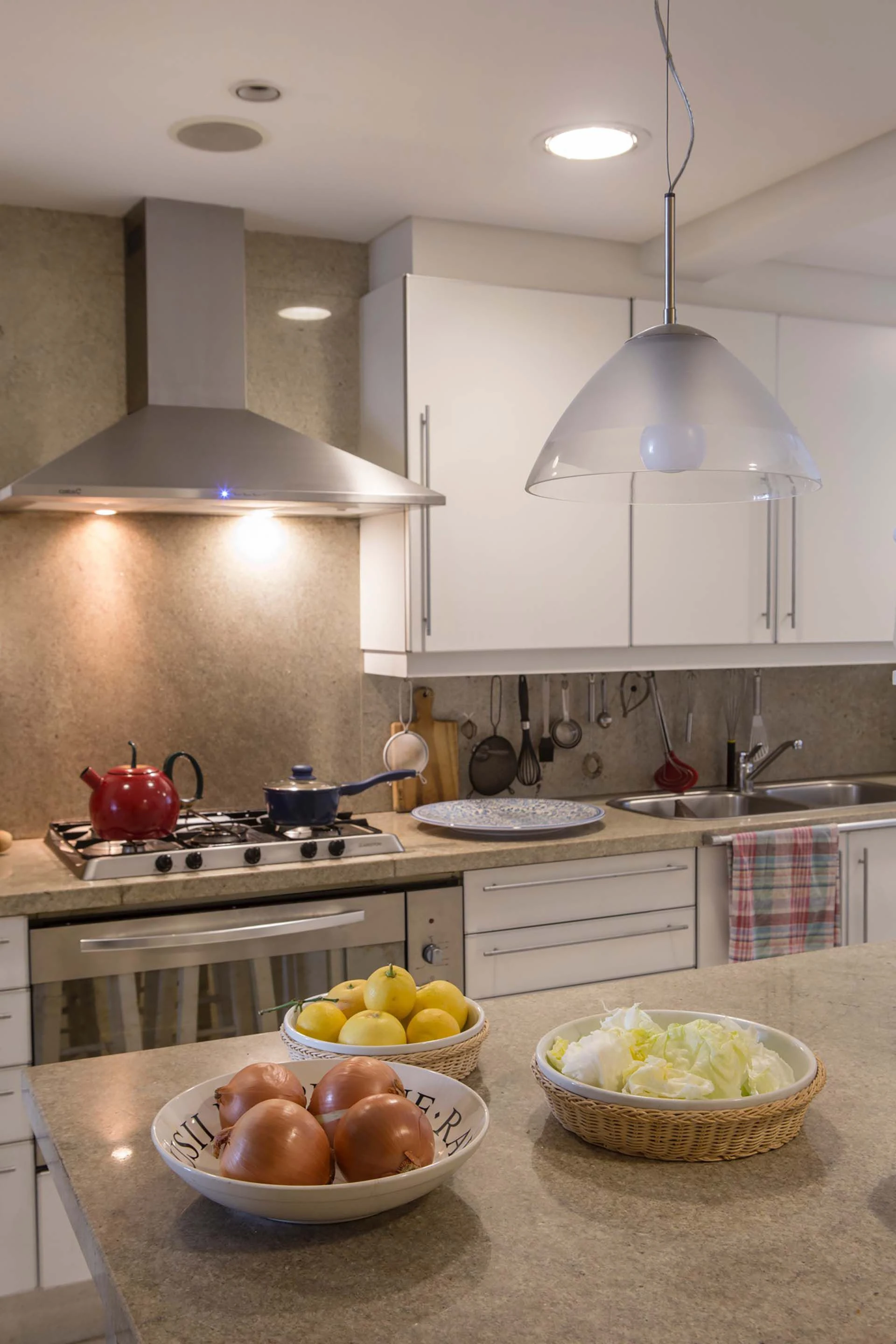 Muebles laqueados en blanco y grandes placas de granito sin pulir para la moderna cocina.