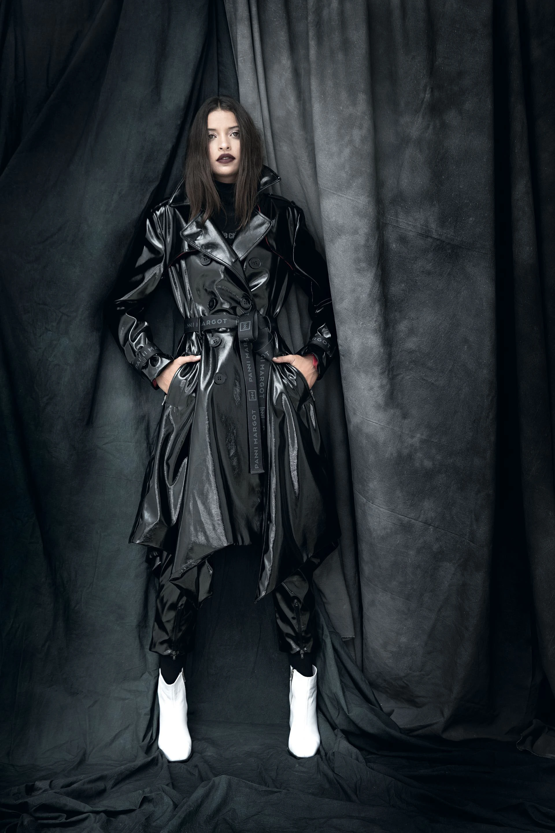 Trench de vinilo con forrería camisera, pantalón de vinilo con cierre en los puños y cinturón industrial. Zapatos (Lorena Pafundi).