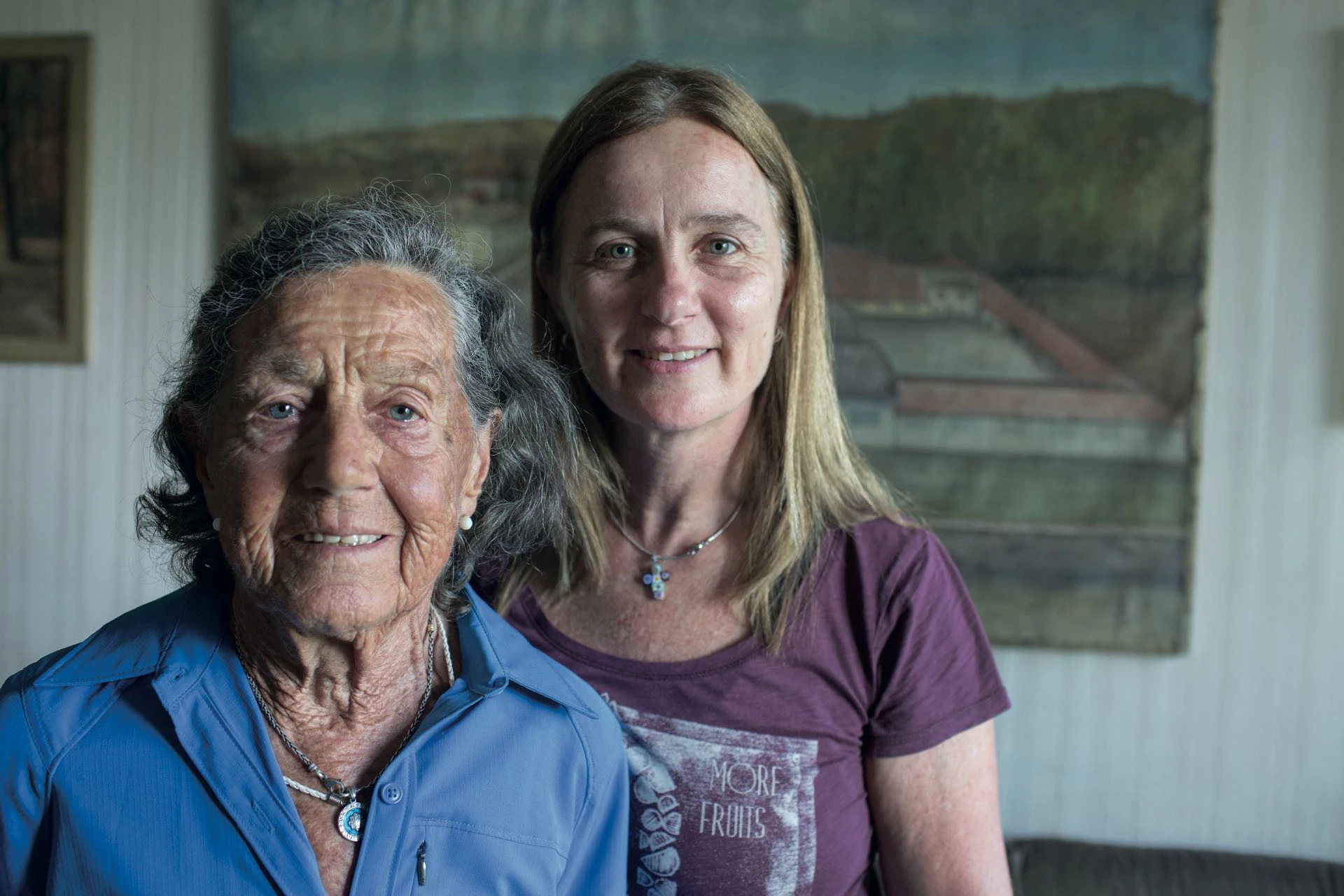 Con Adriana, su hija. Detrás de ellas, el dibujo que hizo su padre de la fábrica de seda que tenían en Italia.