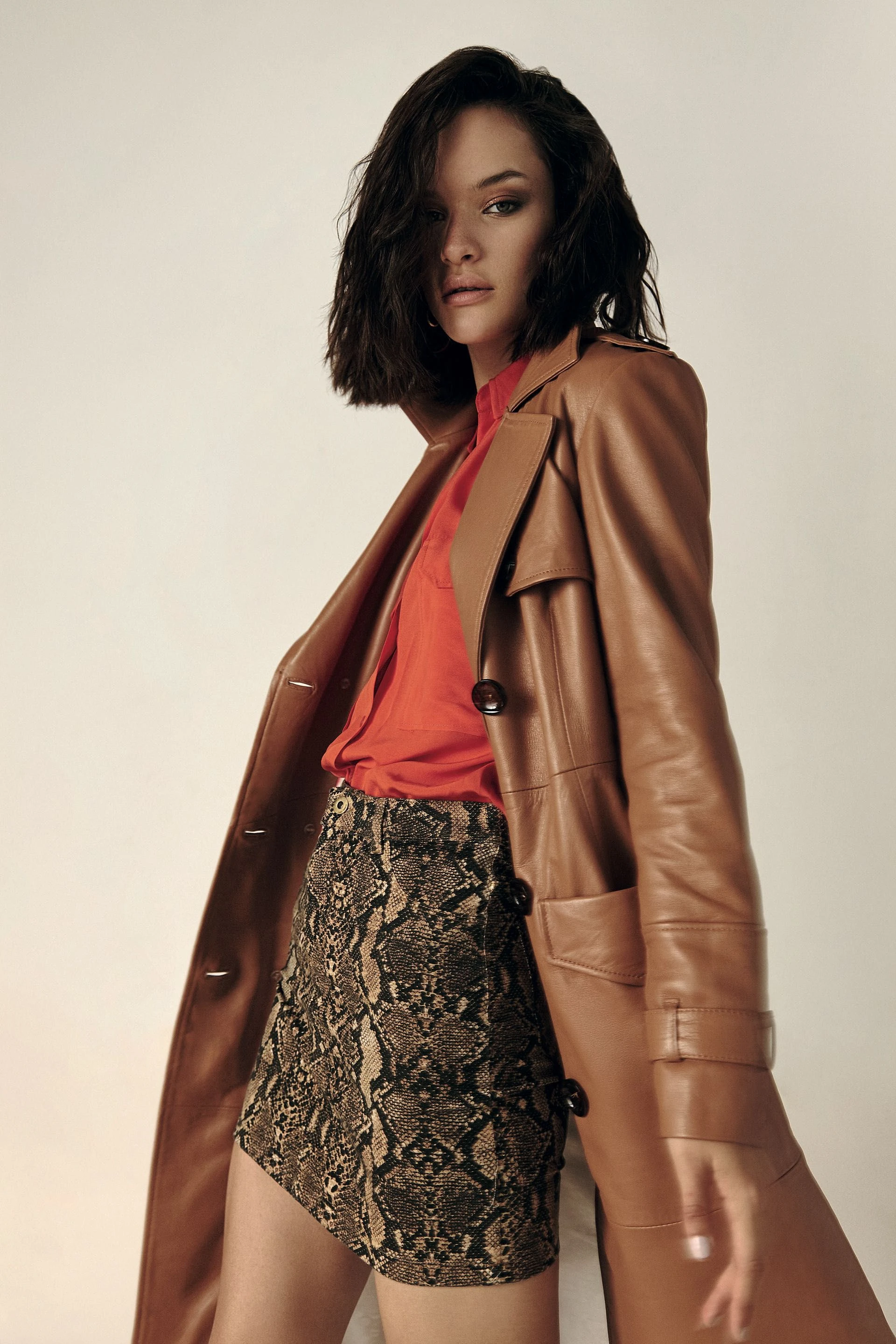 TRENCH DE CUERO ($ 24.990, Las Pepas), CAMISA ($ 2.650, Doll Store), MINI DE REPTIL ($ 1.490, Peuque) y AROS ($ 340, Love Lola).