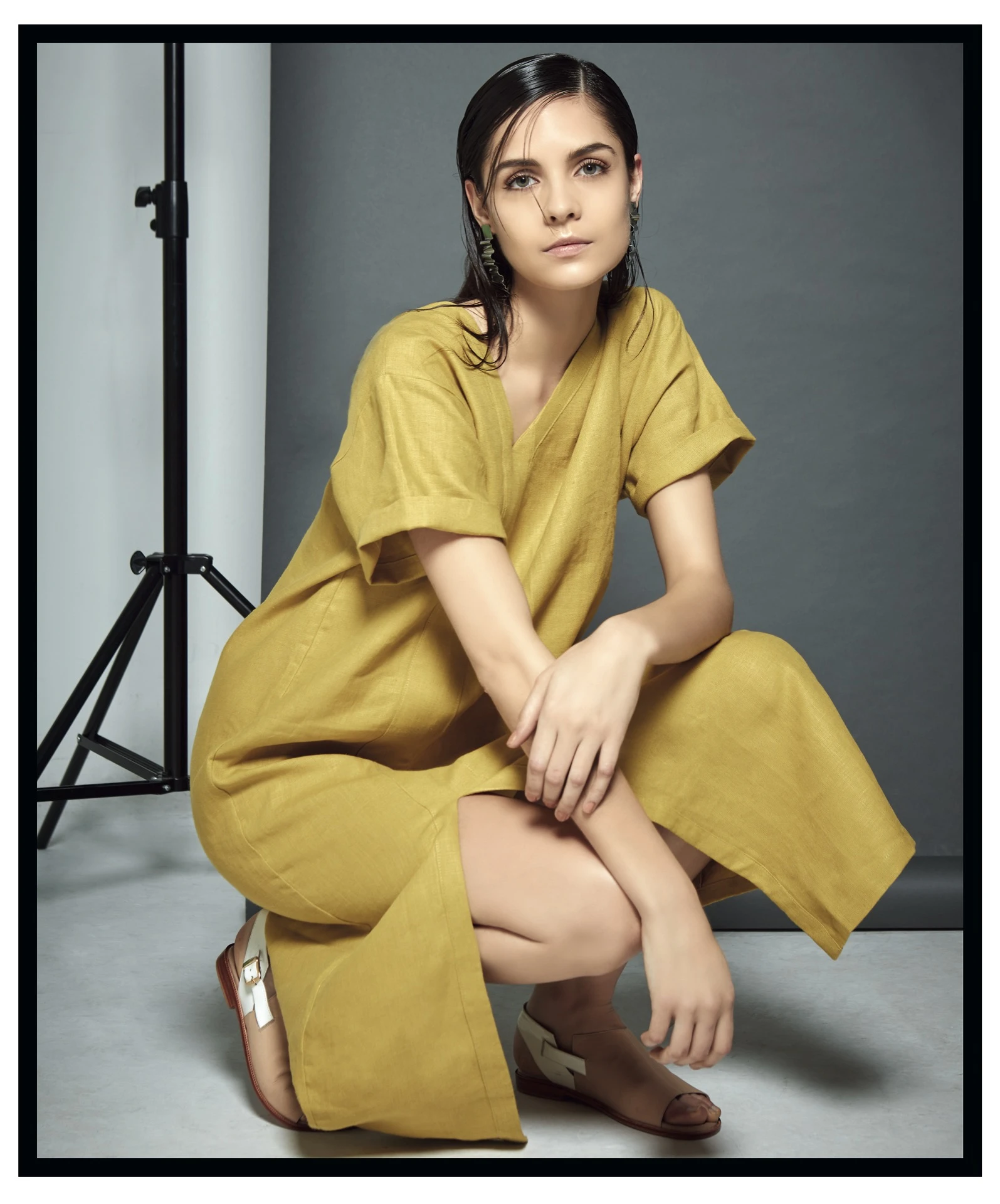 Vestido de escote irregular de lino de algodón y aros (Vernna) y sandalias bicolor (Acento de autor). Foto Ana Fanelli/ Para Ti