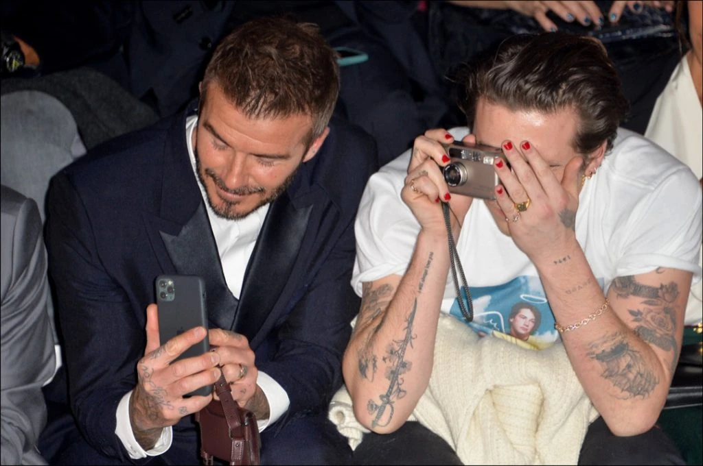 David Beckham y su hijo Brooklyn registrando el desfile de Dior Men en París con su celular. Foto: Fotonoticias.