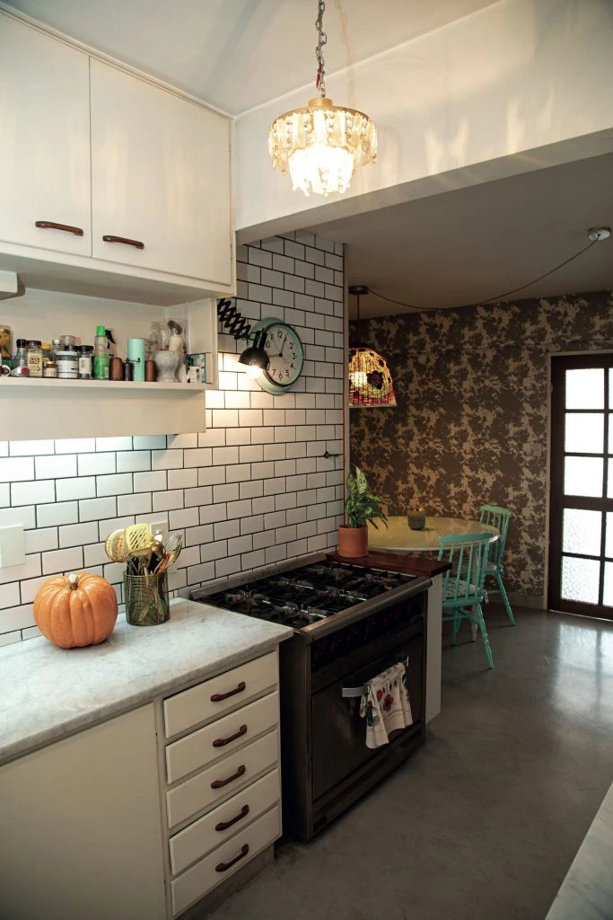 La cocina tiene pisos de cemento alisado y paredes con azulejos subway.