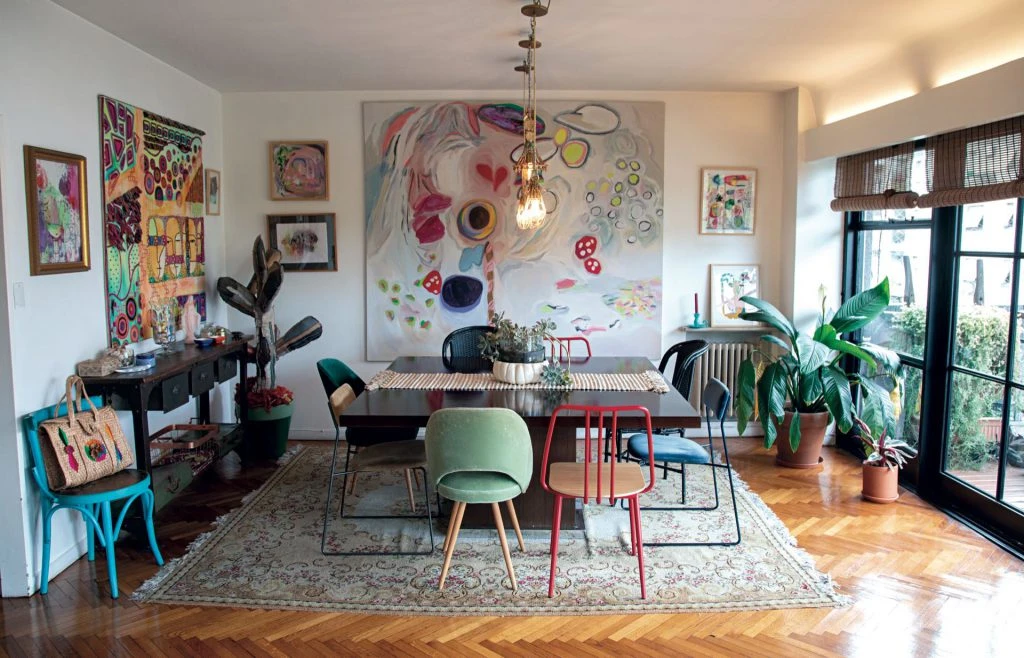 Comedor con cuadros, plantas, tapices y textiles.