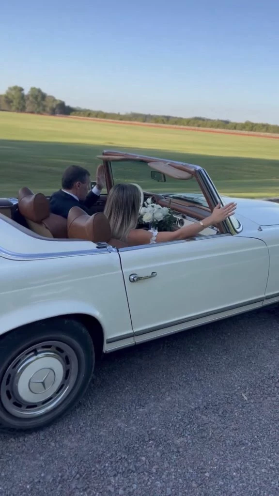 Carolina Calvagni en un auto descapotable vintage junto a su padre camino al altar. Foto: Instagram.