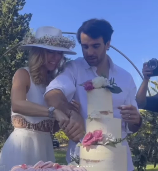 Nicole y Urcera cortando la torta de bodas, que tenia flores naturales.