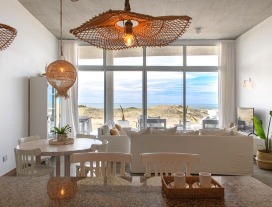 Blanco y madera para un departamento abierto a la playa y el mar