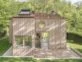 Una mini casa de madera de dos pisos que funciona como refugio de verano