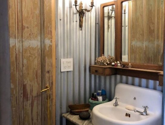 Enamorate de este baño vintage diseñado con paredes de chapa, muebles madera y pisos calcáreos