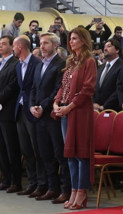 Otra vez junto a Macri, en un acto oficial, Juliana llevó un trench rojo oscuro.