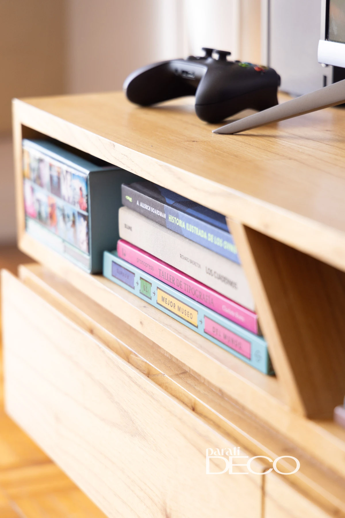 Detalle del mueble retro del televisor + libros + objetos decorativos + la play. 