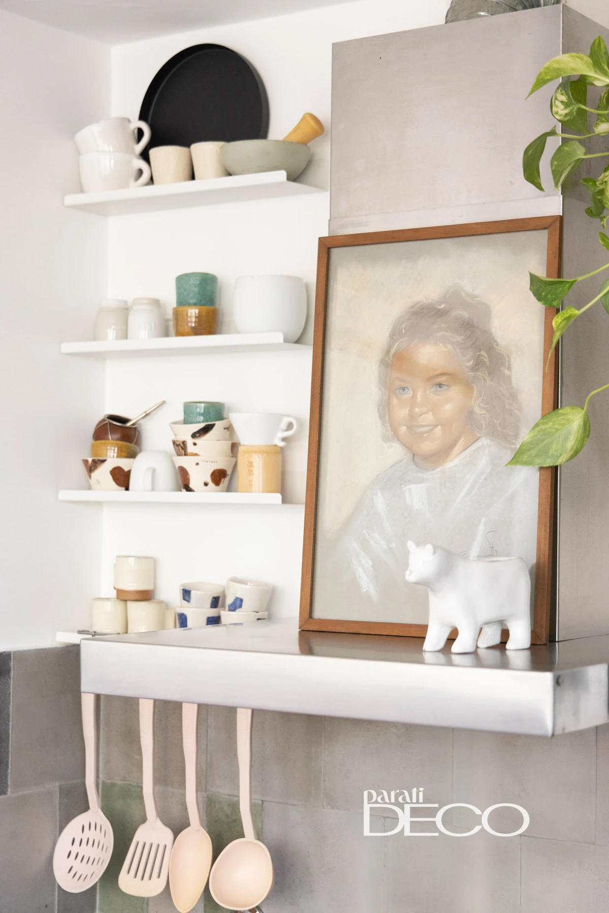 En la cocina, una estantería recibe y exhibe tazas hechas a mano por Caro Bello. 