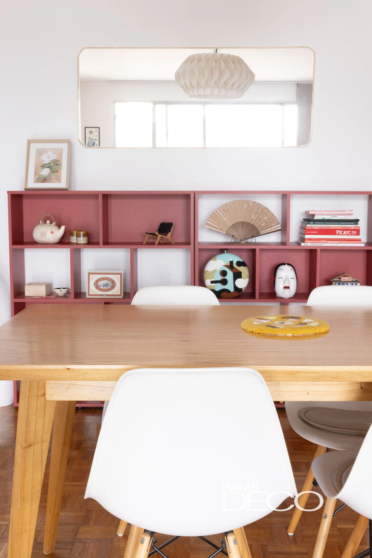 Mesa del comedor, repisa, espejo y lámpara colgante en una distribución y equilibrio preciso. 