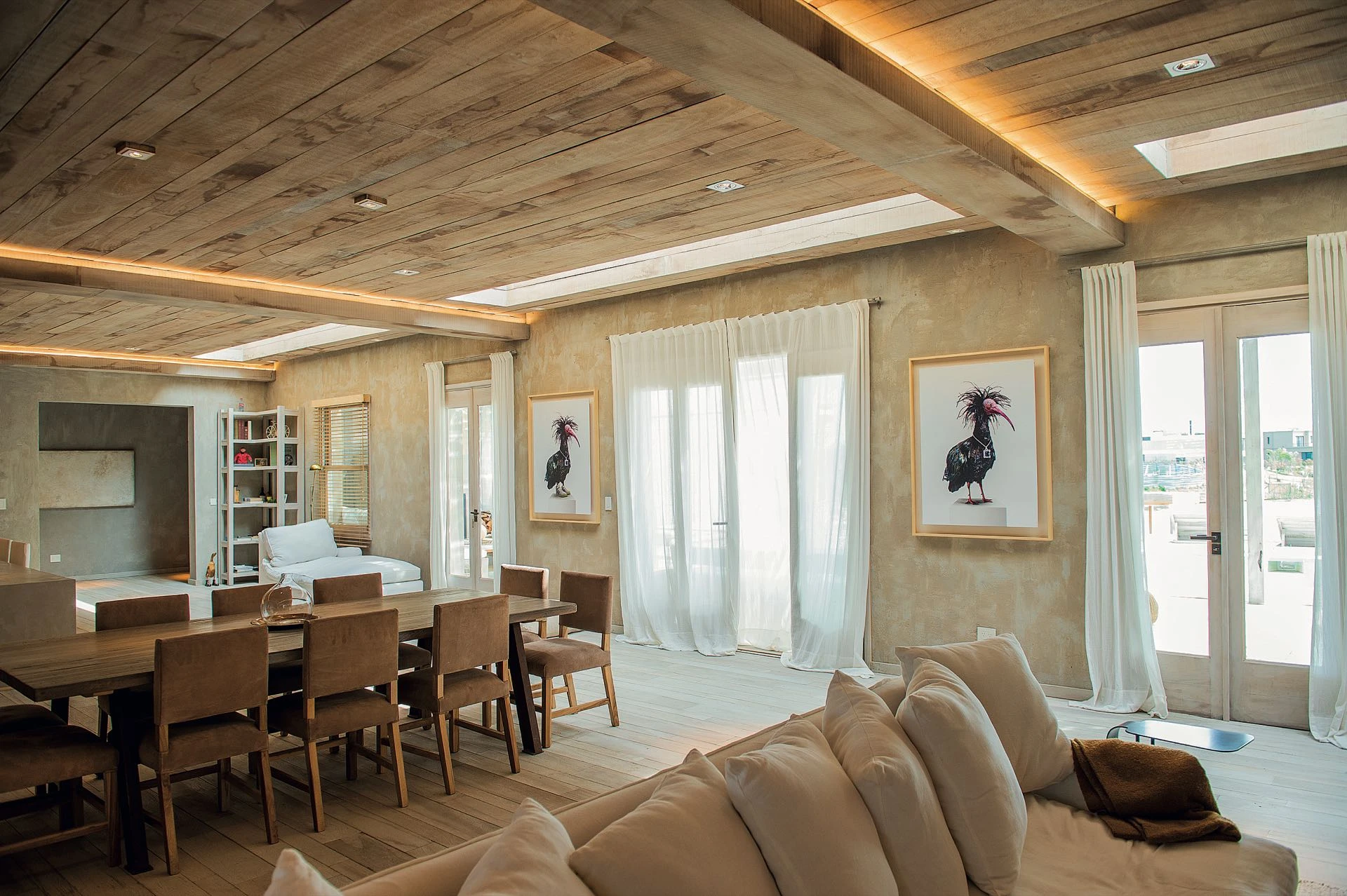 Los colores neutros del living se integran a las tonalidades de la madera del comedor.