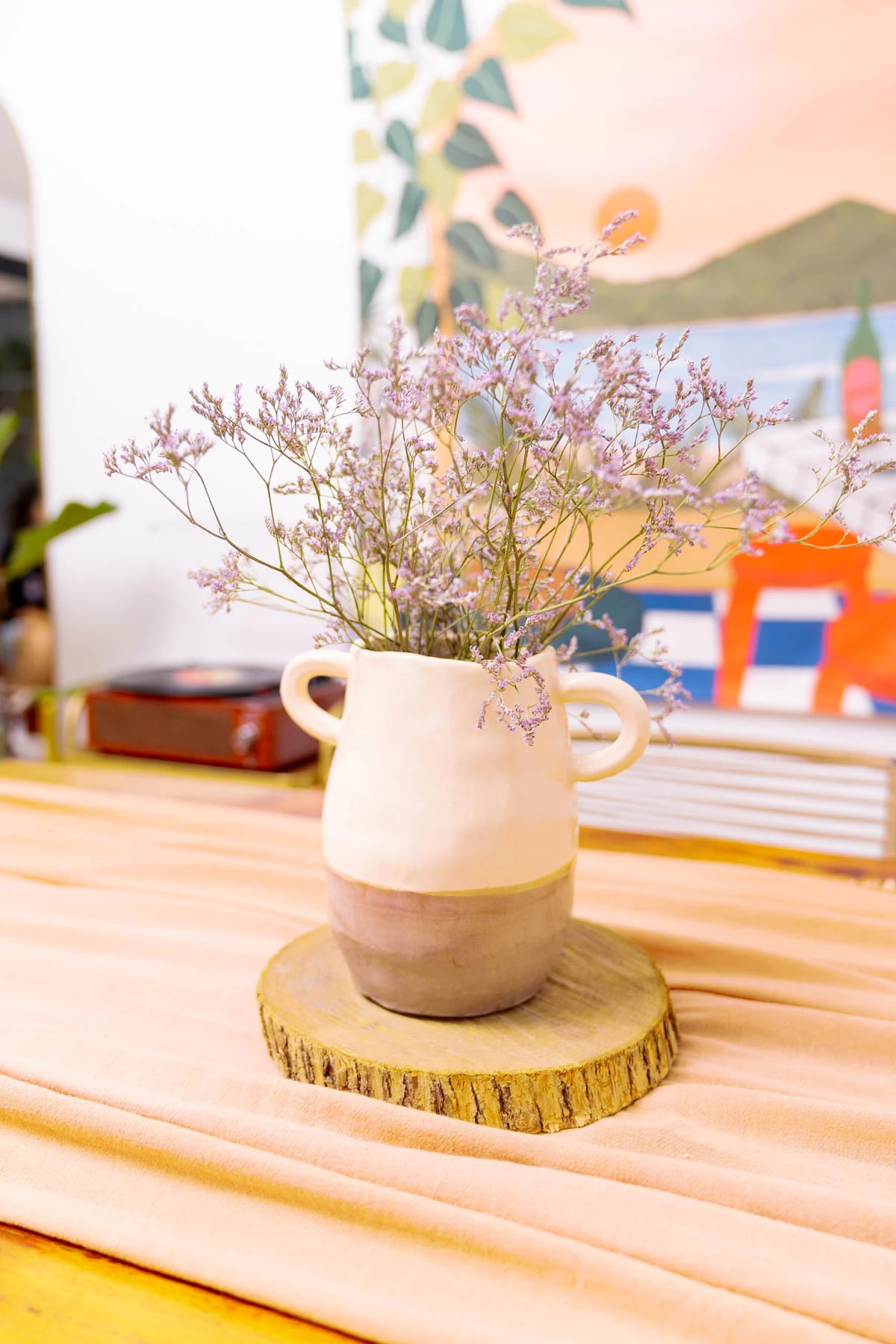 Sobre la mesa del comedor, un florero de cerámica artenal hecho por Laura.