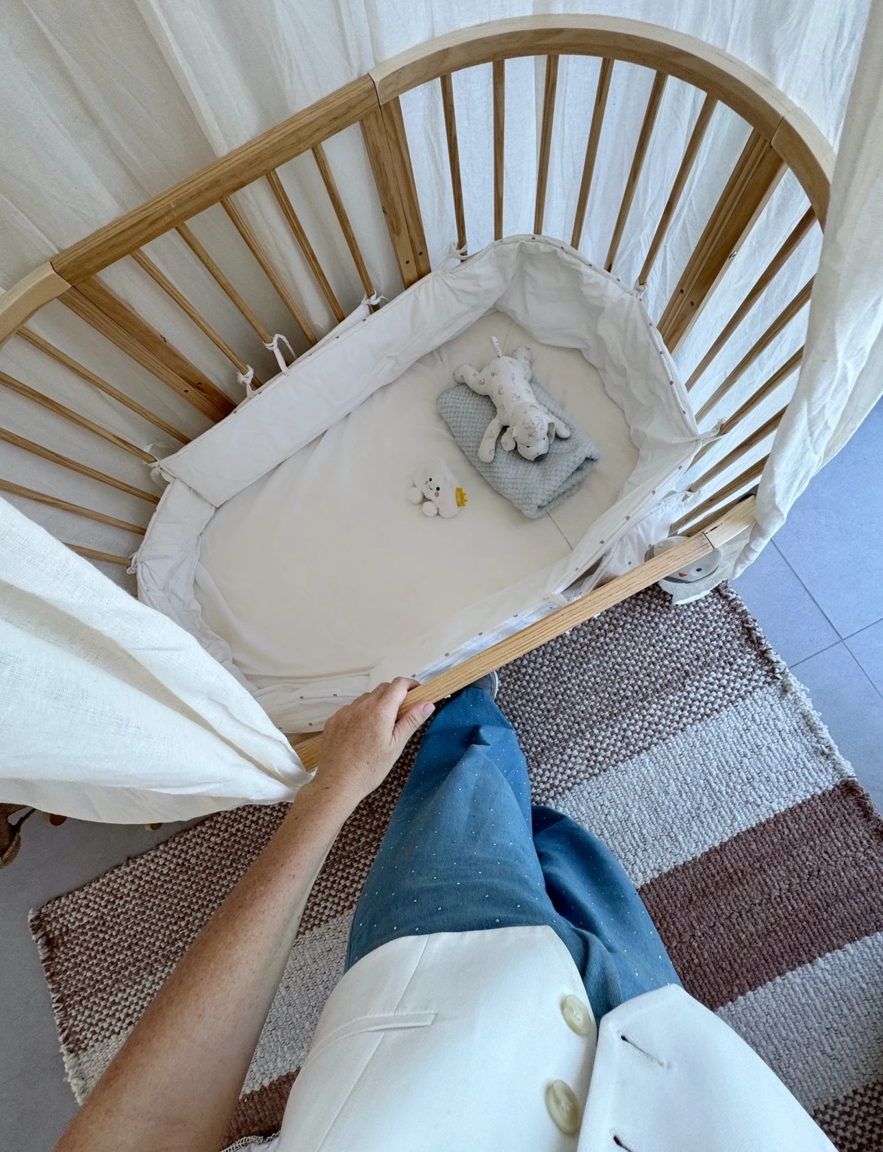 Cuna y alfombra en una composición perfecta en el dormitorio del bebé de Clara Houssay.