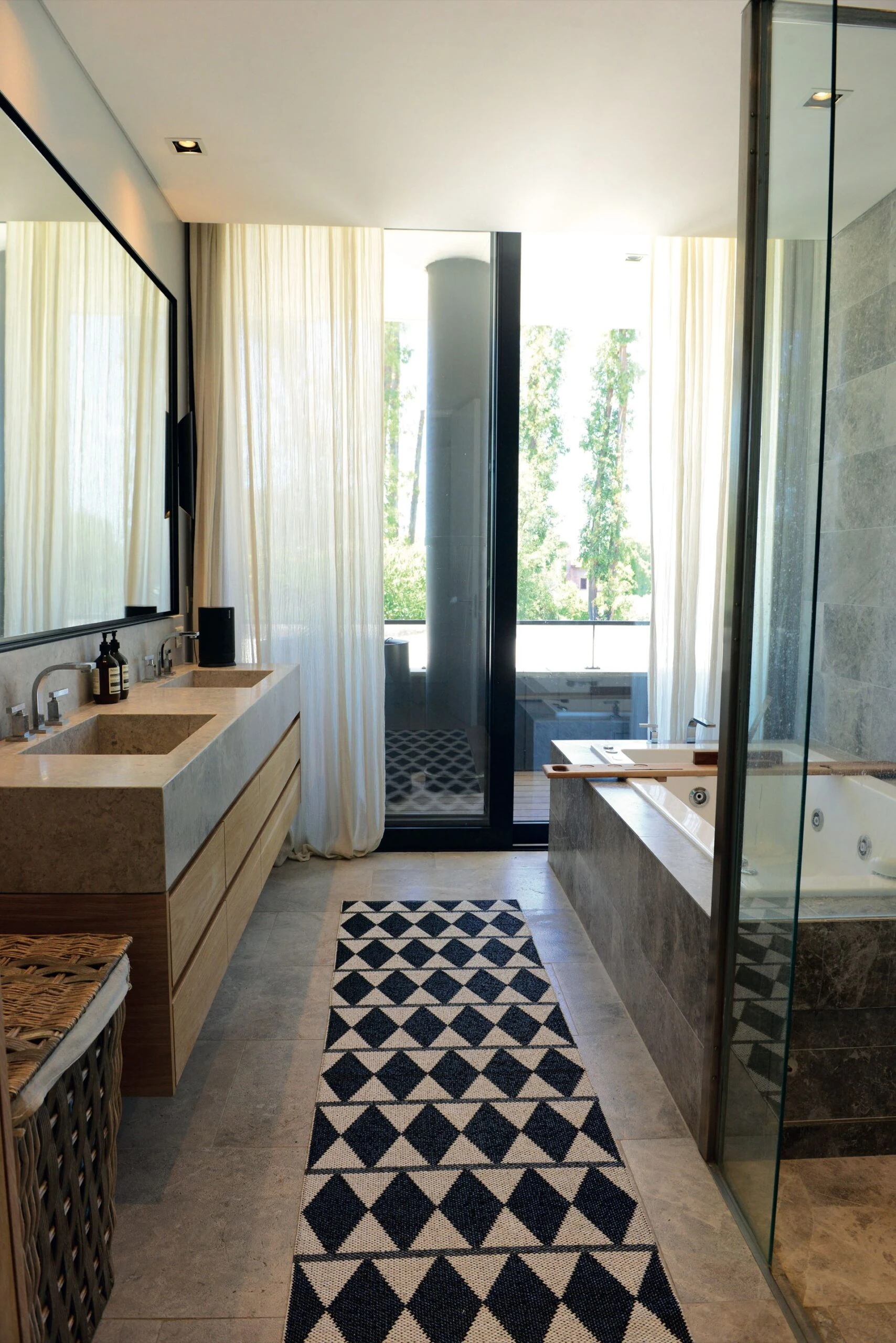 En el baño, el detalle de la alfombra potencia su impacto visual. 