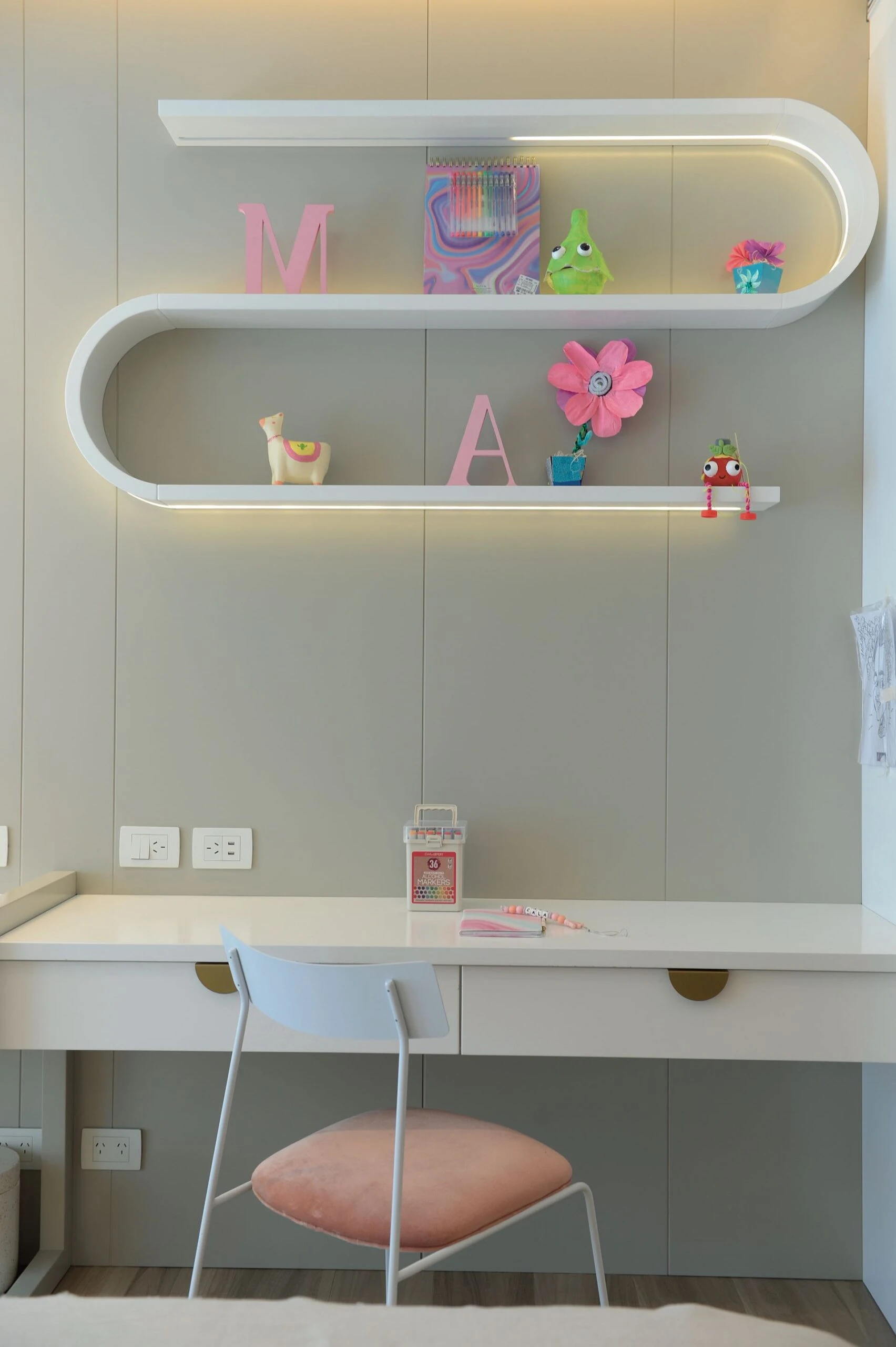 2.Una estantería en zigzag. En laca blanca, es el detalle singular del escritorio para hacer la tarea, más una silla con asiento en rosa pastel haciendo juego.  