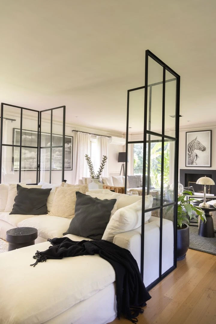 Un cómodo sillón en “L” tapizado en lino, con manta y almohadones a contratono conforma este ambiente resuelto de cara a la tevé.