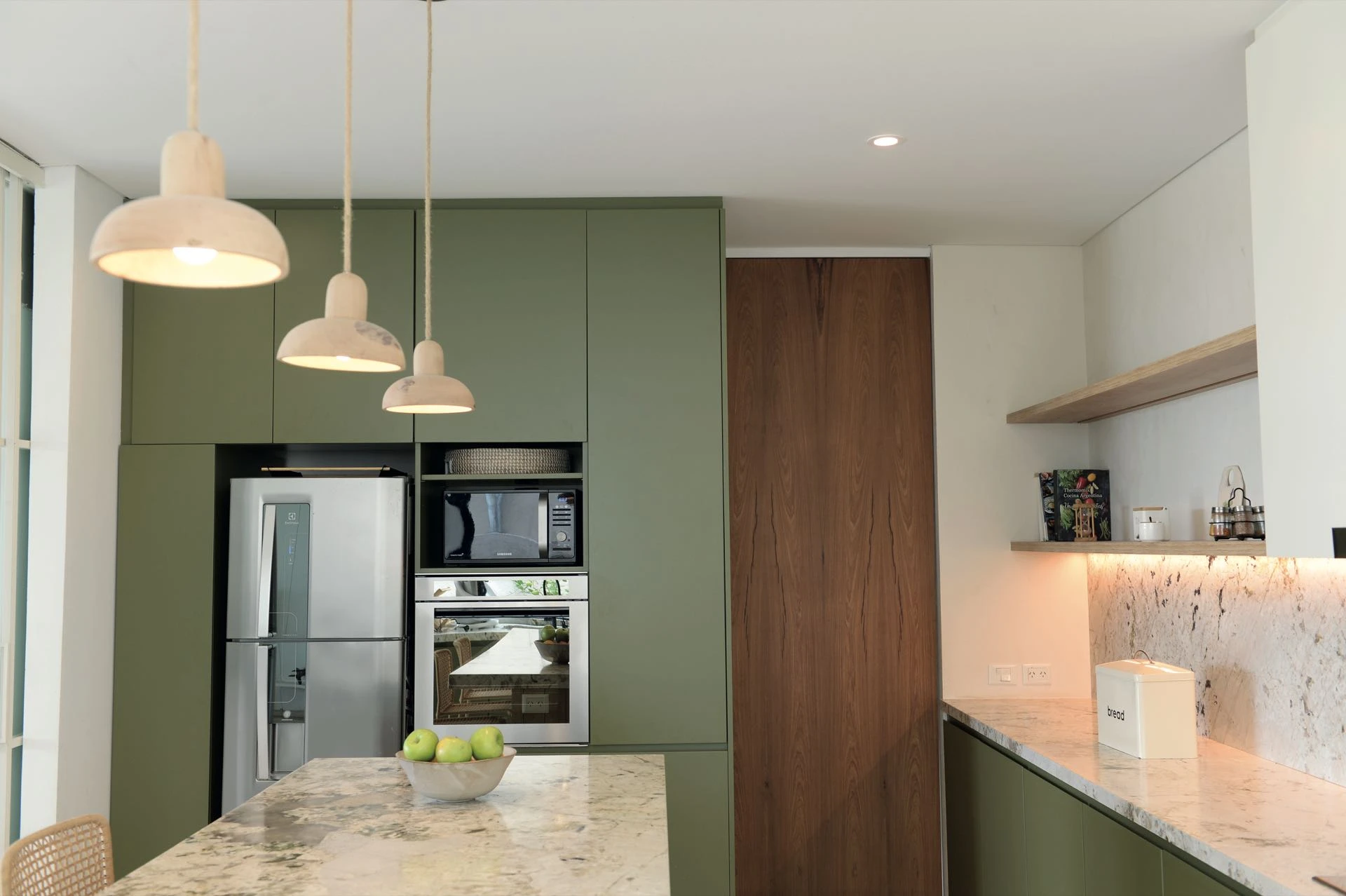 El verde seco define el clima en la cocina semi integrada al comedor. 