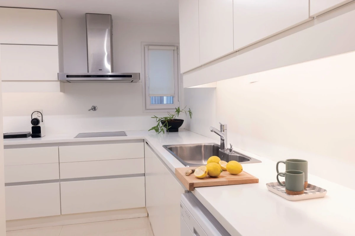 La cocina de diseño simple y basada en la iluminación que expande y ordena.