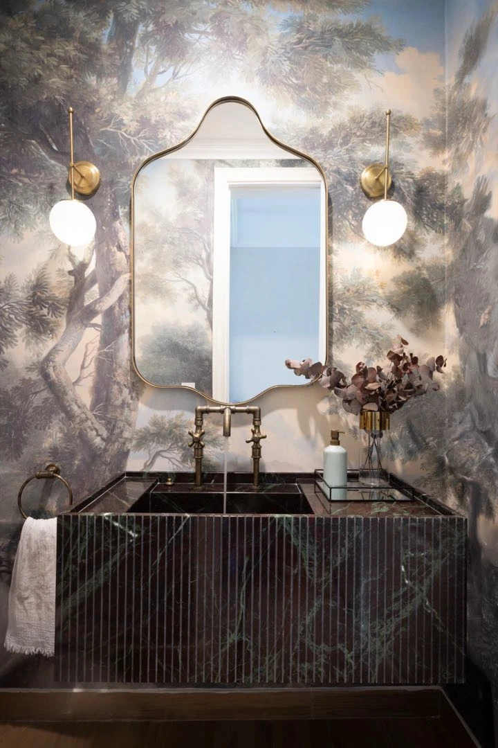 El papel mural y la bacha de mármol con finas líneas verticales se llevan los aplausos en este toilette.