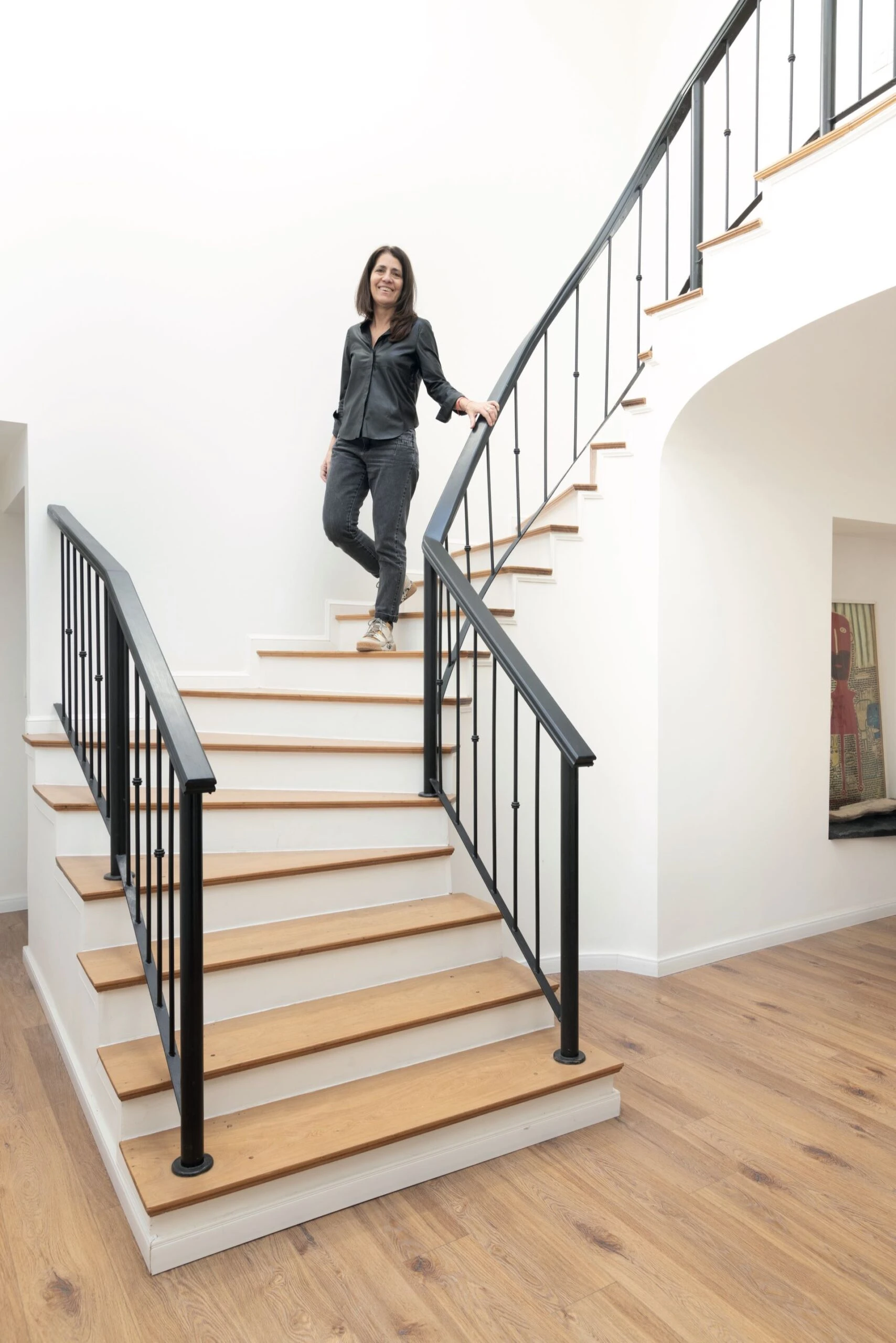 La interiorista Gisela Literas en la escalera que se lijó para sacar el tono tan oscuro y “revelar” la madera de cedro blanco.