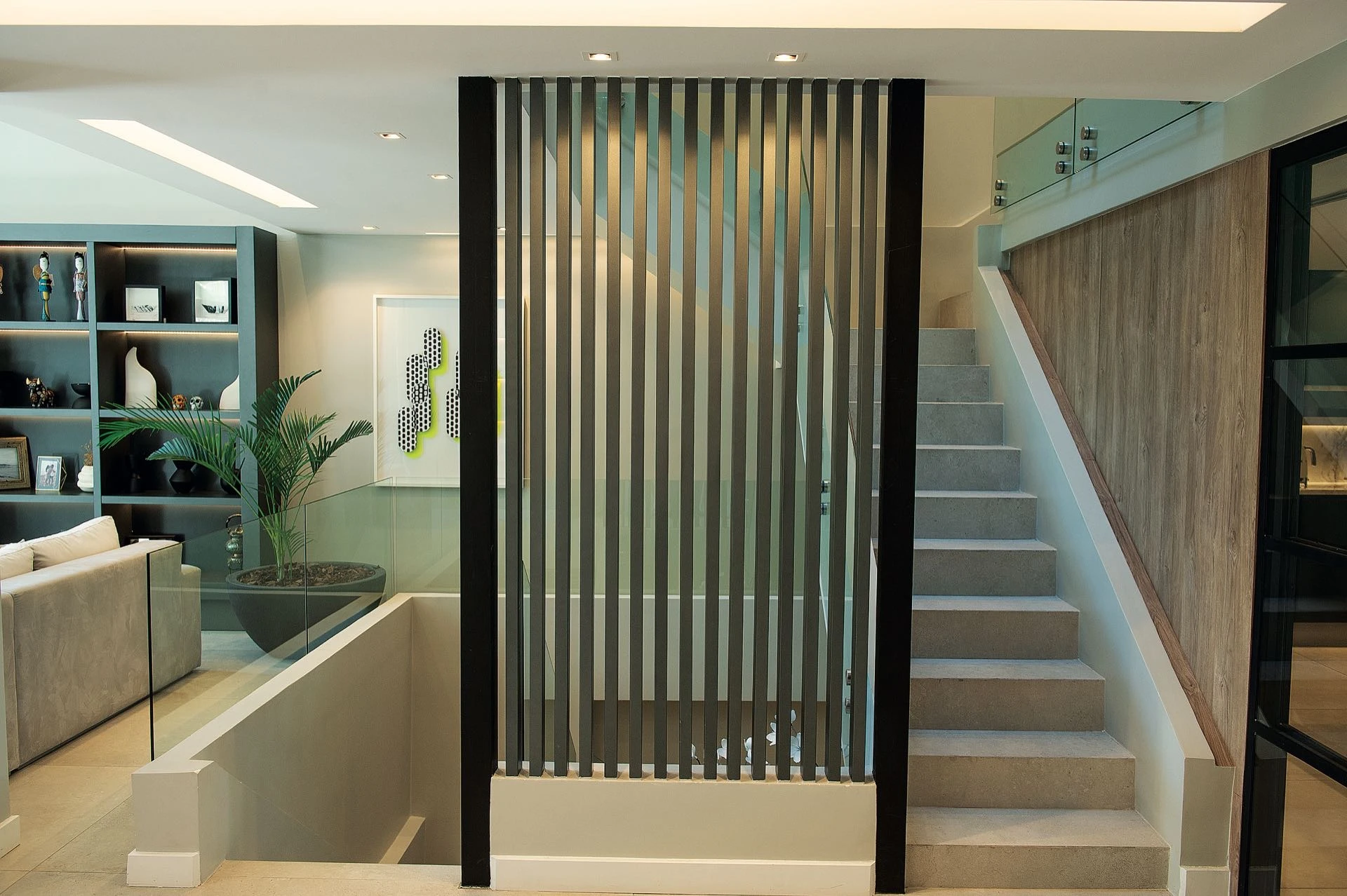 Una caja de escalera vidriada envuelve los tramos que suben y bajan.