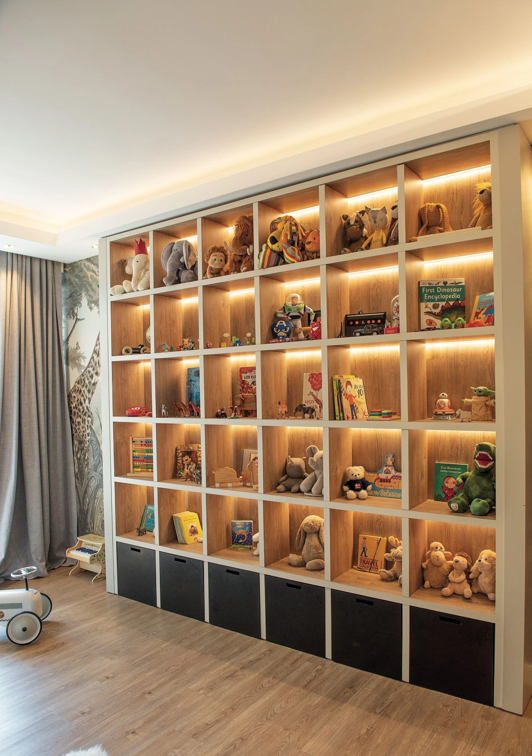 Una gran biblioteca con juguetero y espacios de guardado.