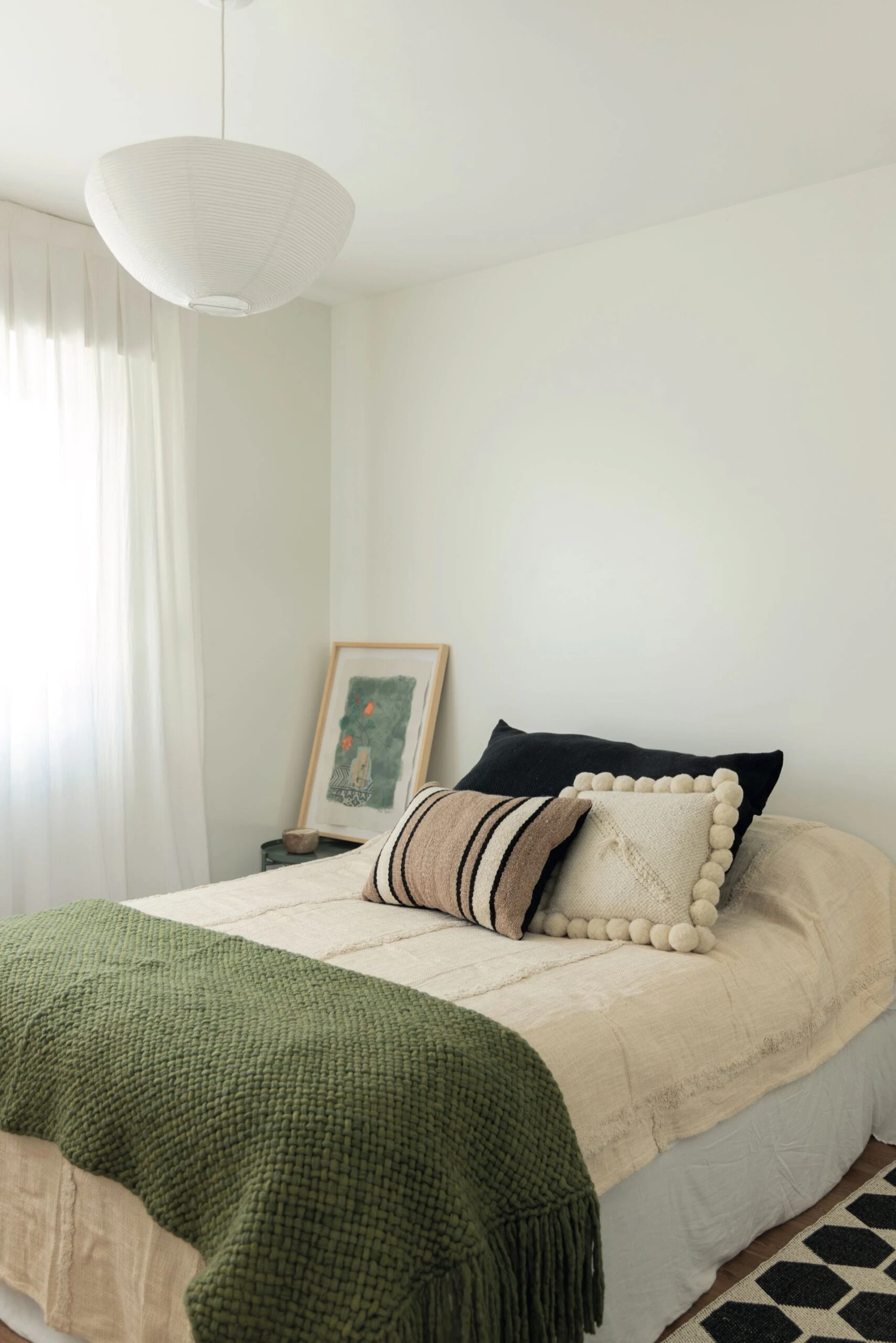 Almohadones, una manta verde de la tienda Alma mia de Pergamino y alfombra de la marca sueca Brita visten otro dormitorio.