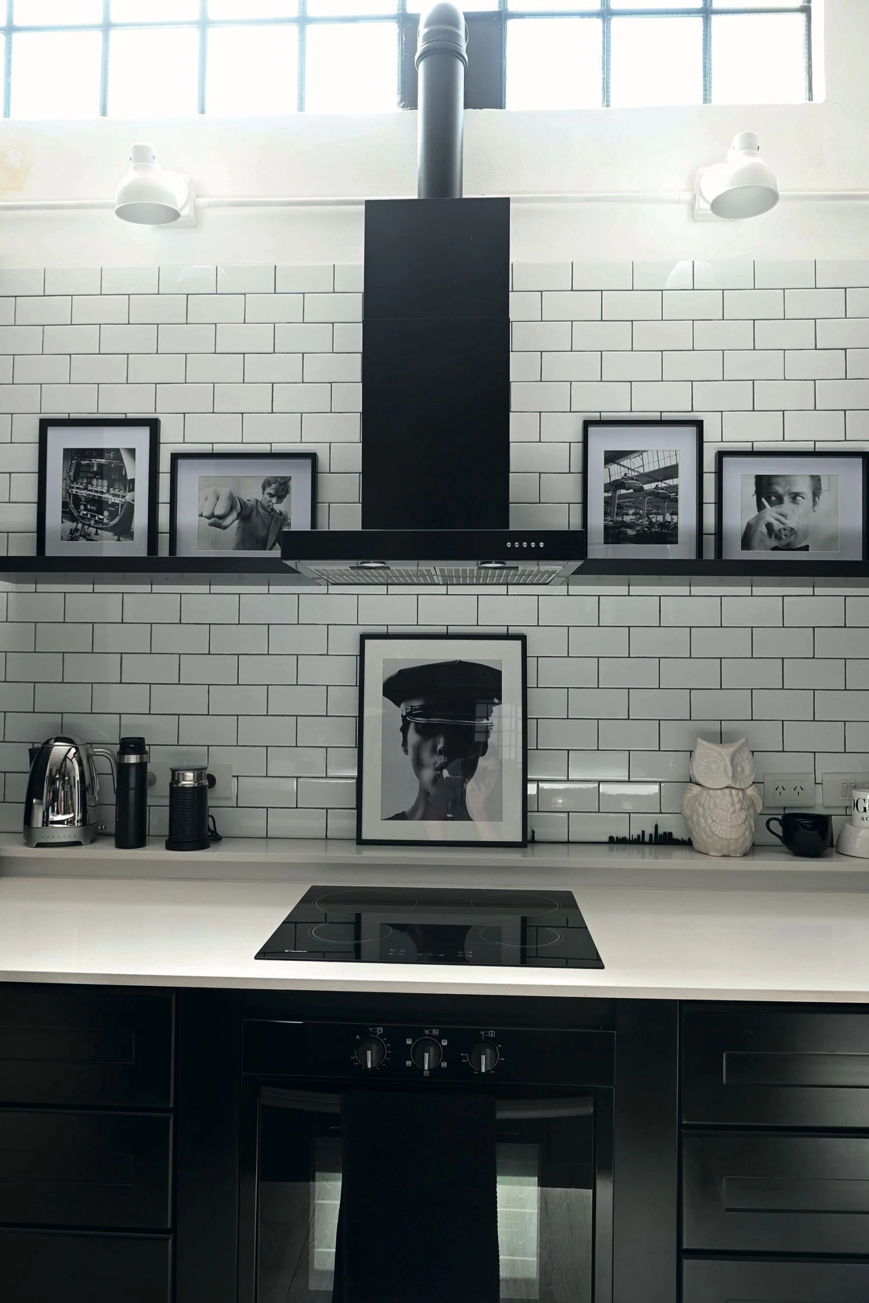 Al centro de la zona de trabajo, sobre la placa de anafe, un extractor negro mate (Atma). 