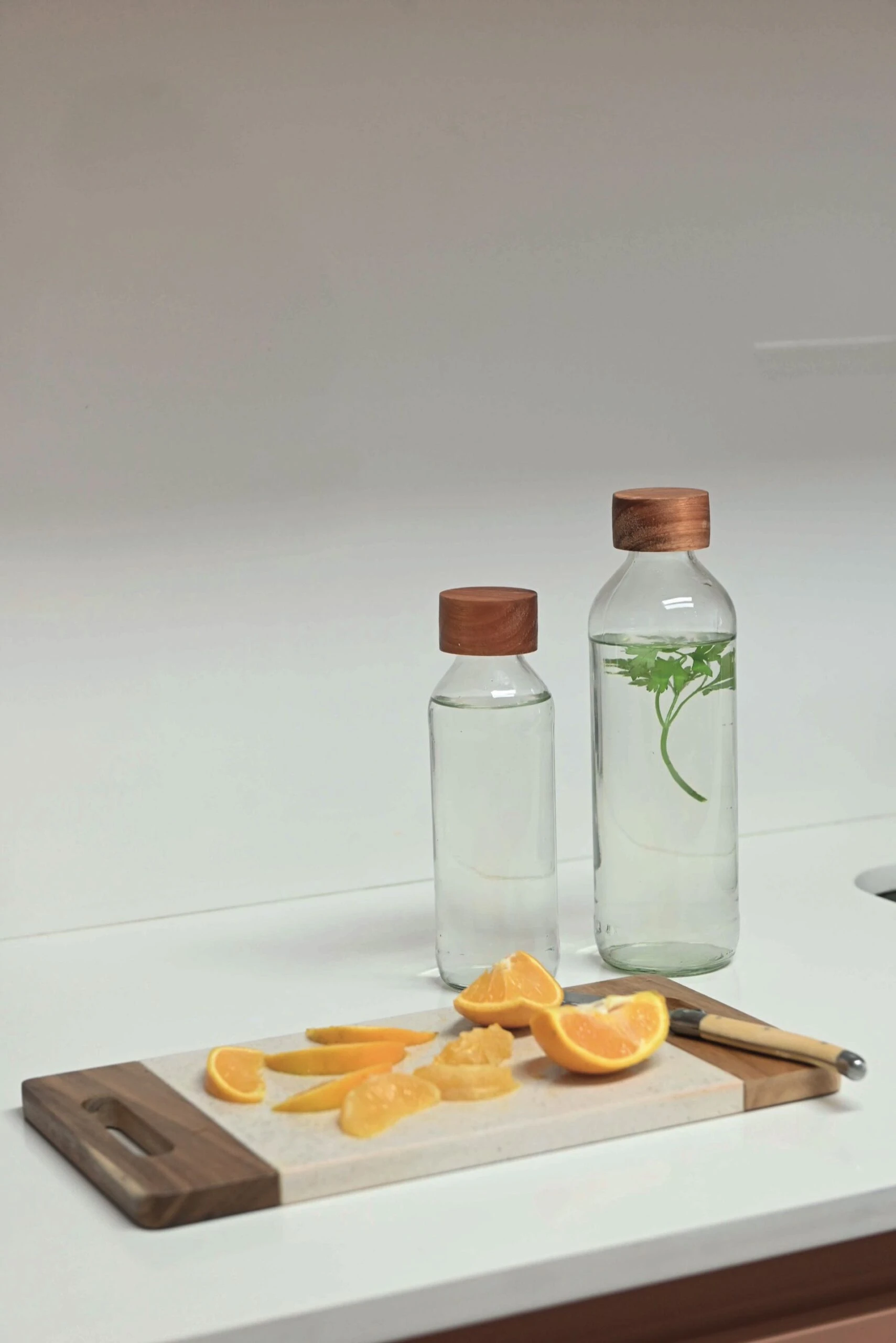 Sobre la mesada, una tabla con limones y dos botellas de agua. 