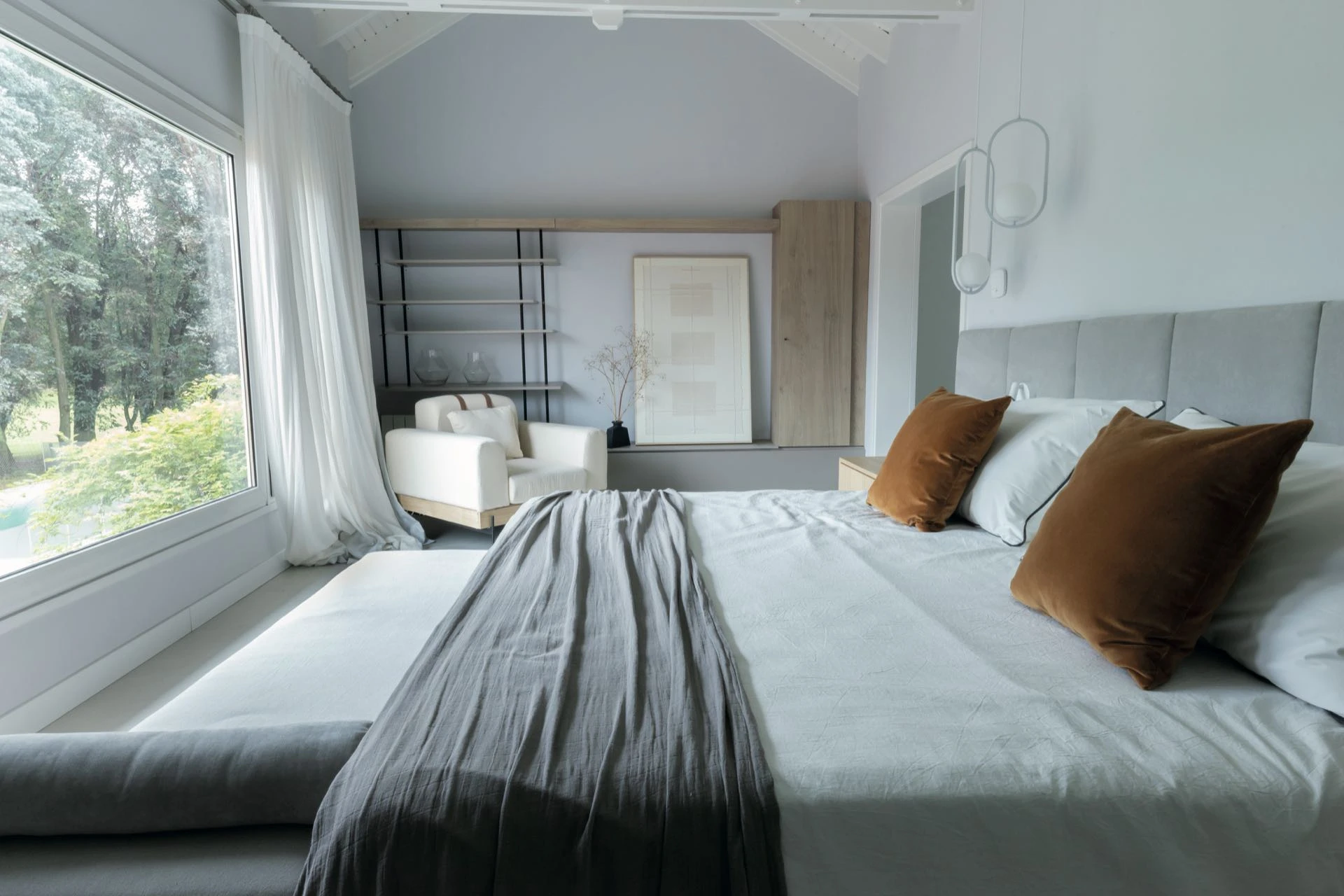 Un dormitorio de colores cálidos y con vista hacia el exterior.