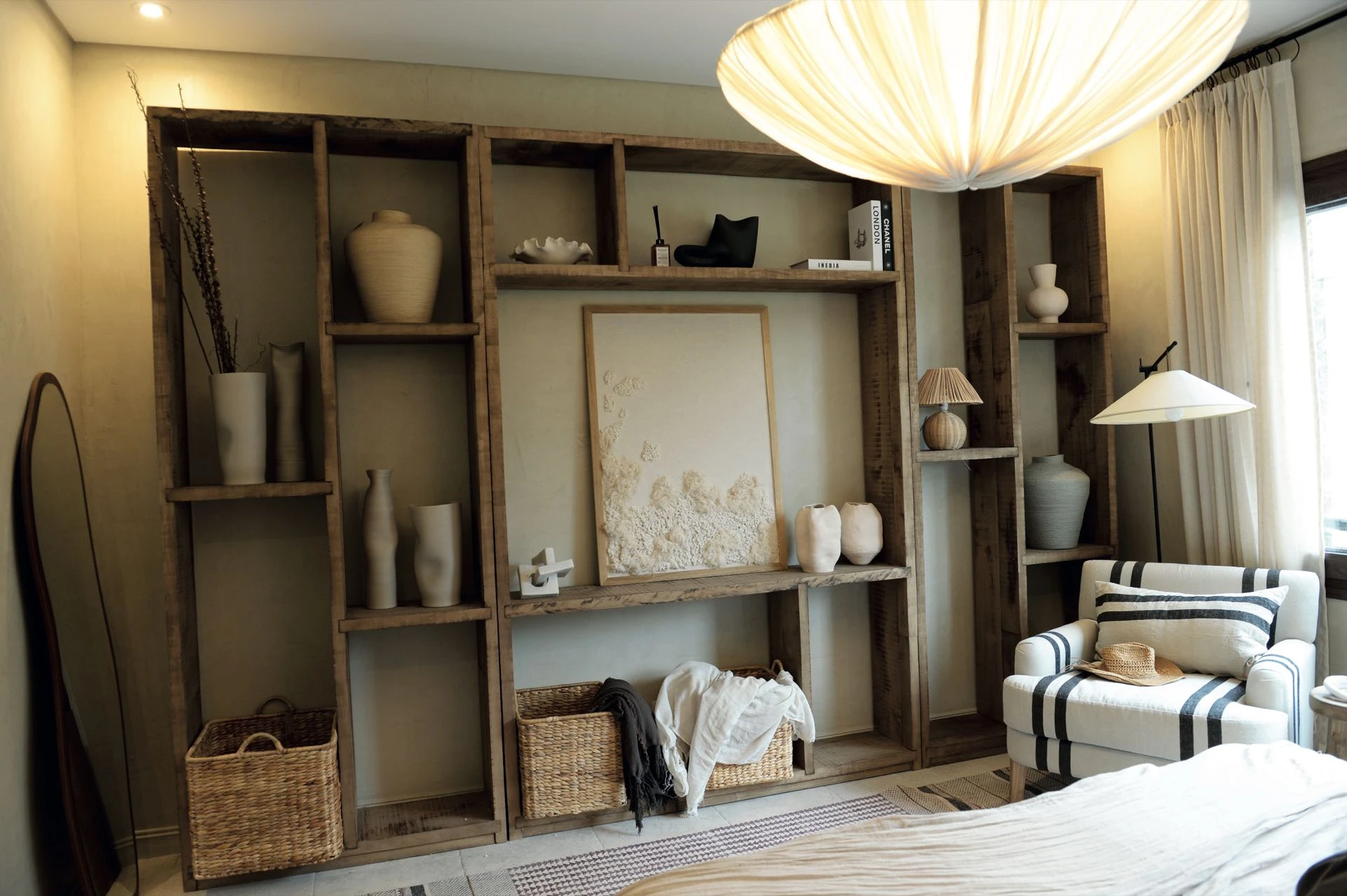 Frente a la cama, hay una biblioteca de kiri teñido rústico.