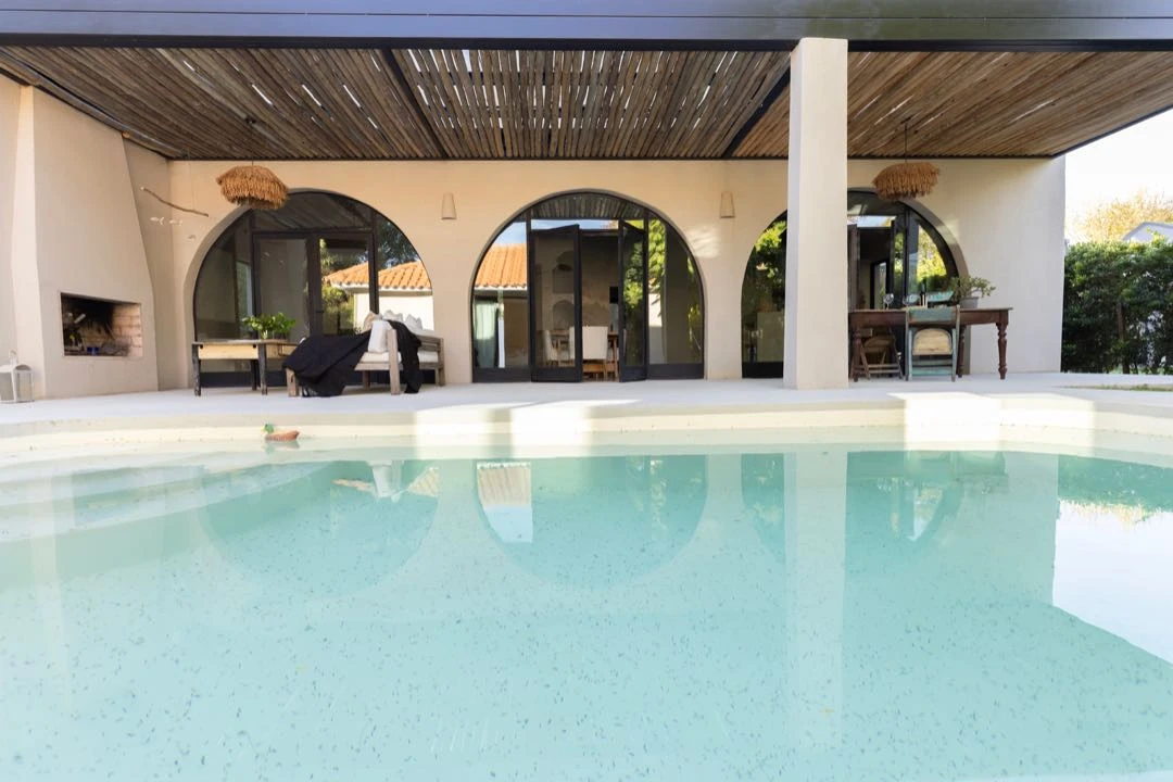 Una pileta de gran tamaño separa a la casa del dormitorio principal en suite.