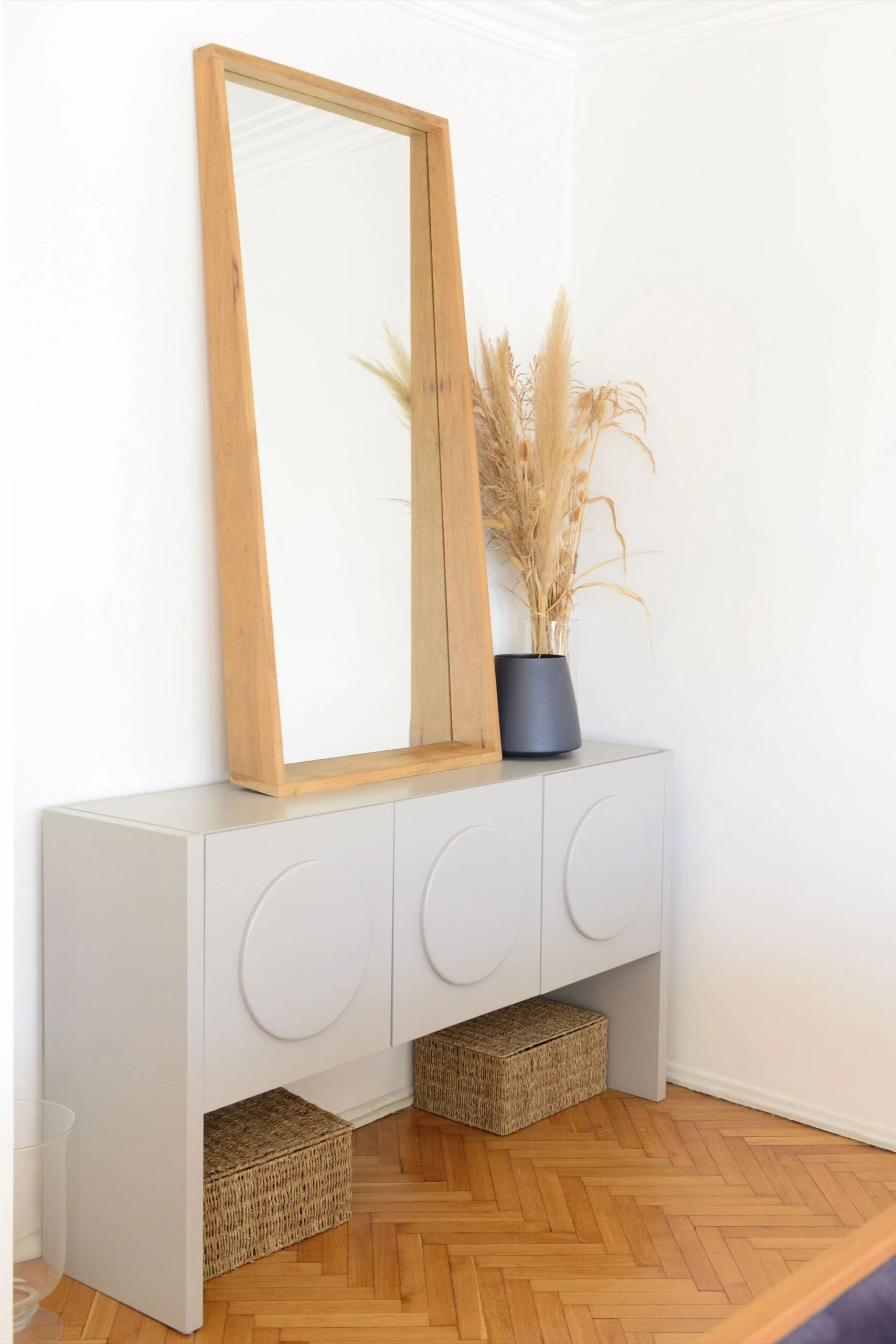 Gran espejo de fondo (Casandra Estudio), vasija azul (Gris Dimensión) y consola (Bull).