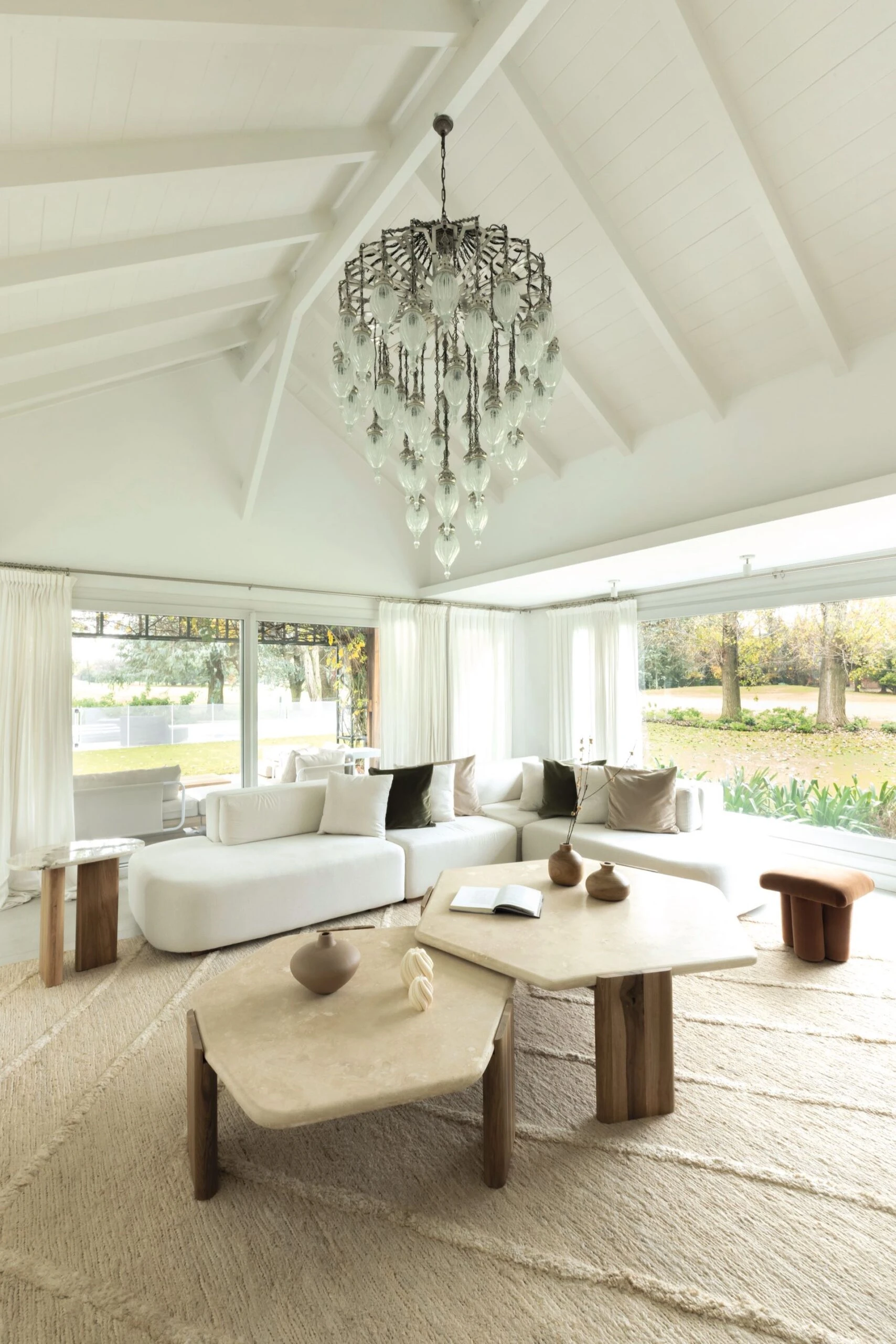 El punto focal lo da la imponente araña de vidrio que cuelga del techo a dos aguas pintado de blanco.