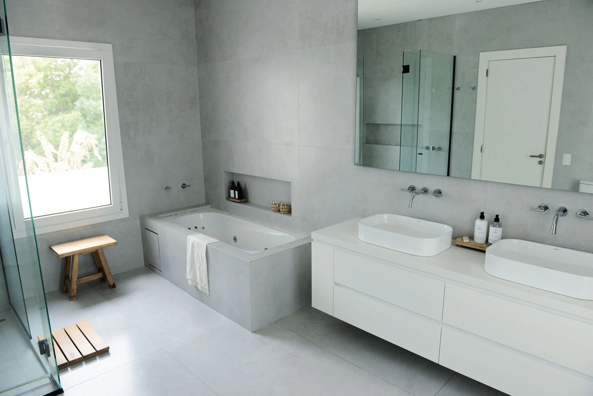  la monocromía en blanco vuelve con todo en el baño principal, íntegramente revestido con porcelanatos. 