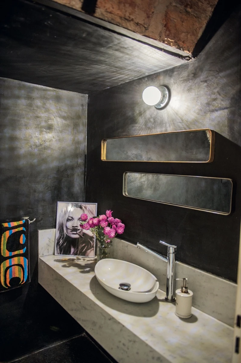 En el toilette las paredes son de microcemento negro. 