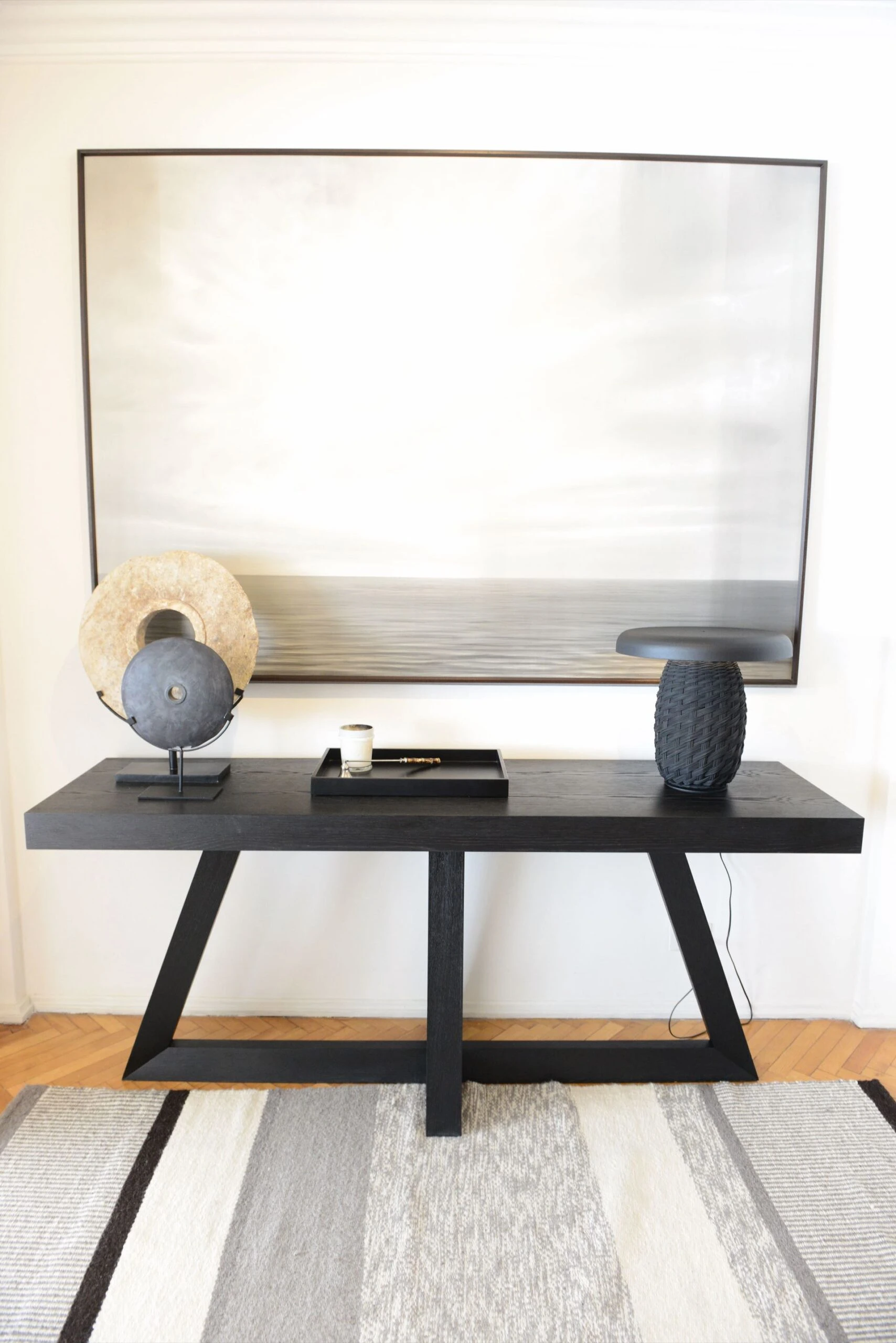 En el hall de entrada, una consola de roble americano teñido de negro (Somos Frontera) dialoga con un cuadro de Patrick Glascher.