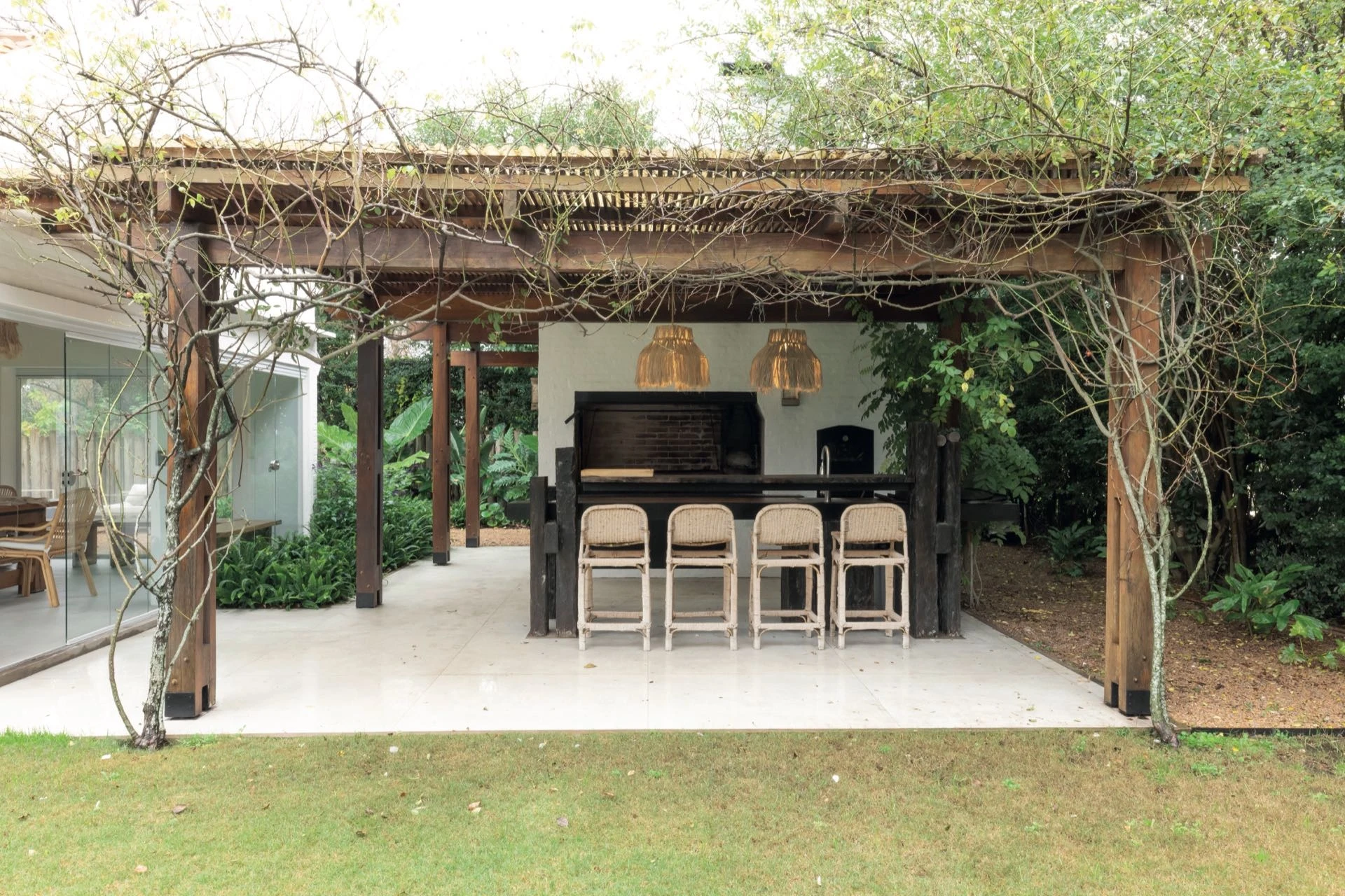El sector parrilla, resuelto bajo una pérgola cubierta de enredaderas.
